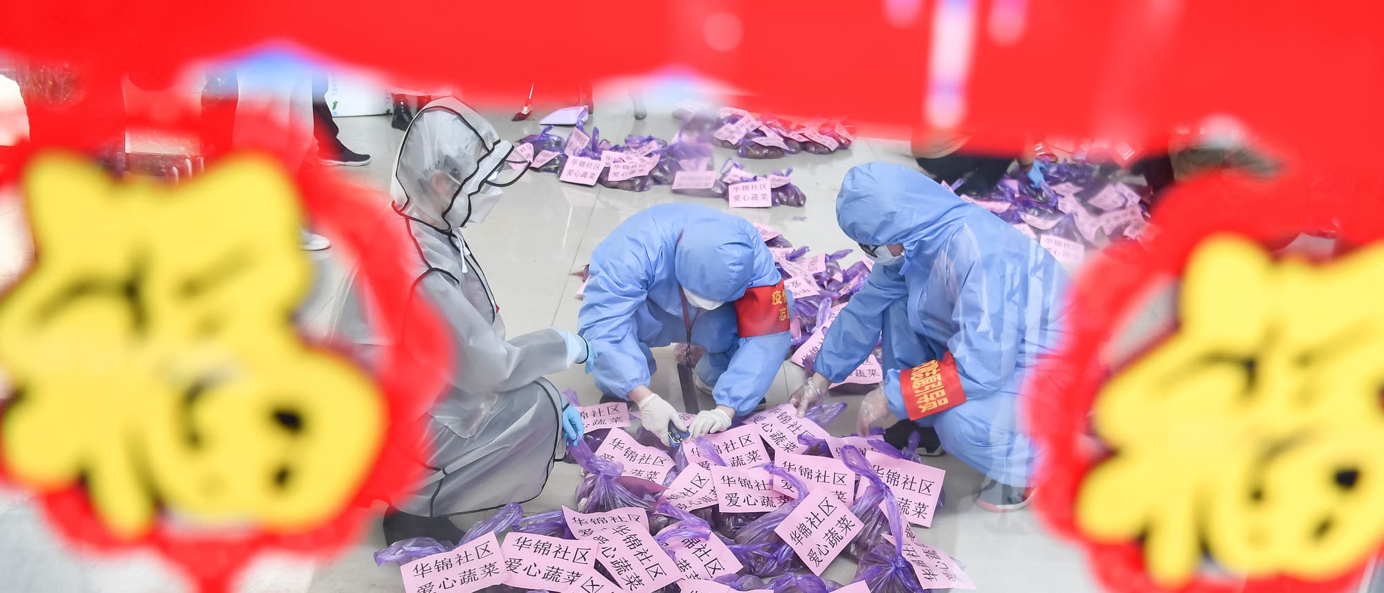 Coronavirus-Epidemie in China:Drei Personen in Schutzanzügen sortieren Versorgungsgüter für Menschen in Quarantäne.