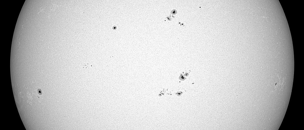 Una imagen detallada de la superficie del sol, que muestra varias manchas solares oscuras. Estas manchas están distribuidas irregularmente y varían en tamaño. La superficie del sol parece granulada, lo que indica granulación. Abajo en la imagen está la URL "www.frank-stefani.de" visible.