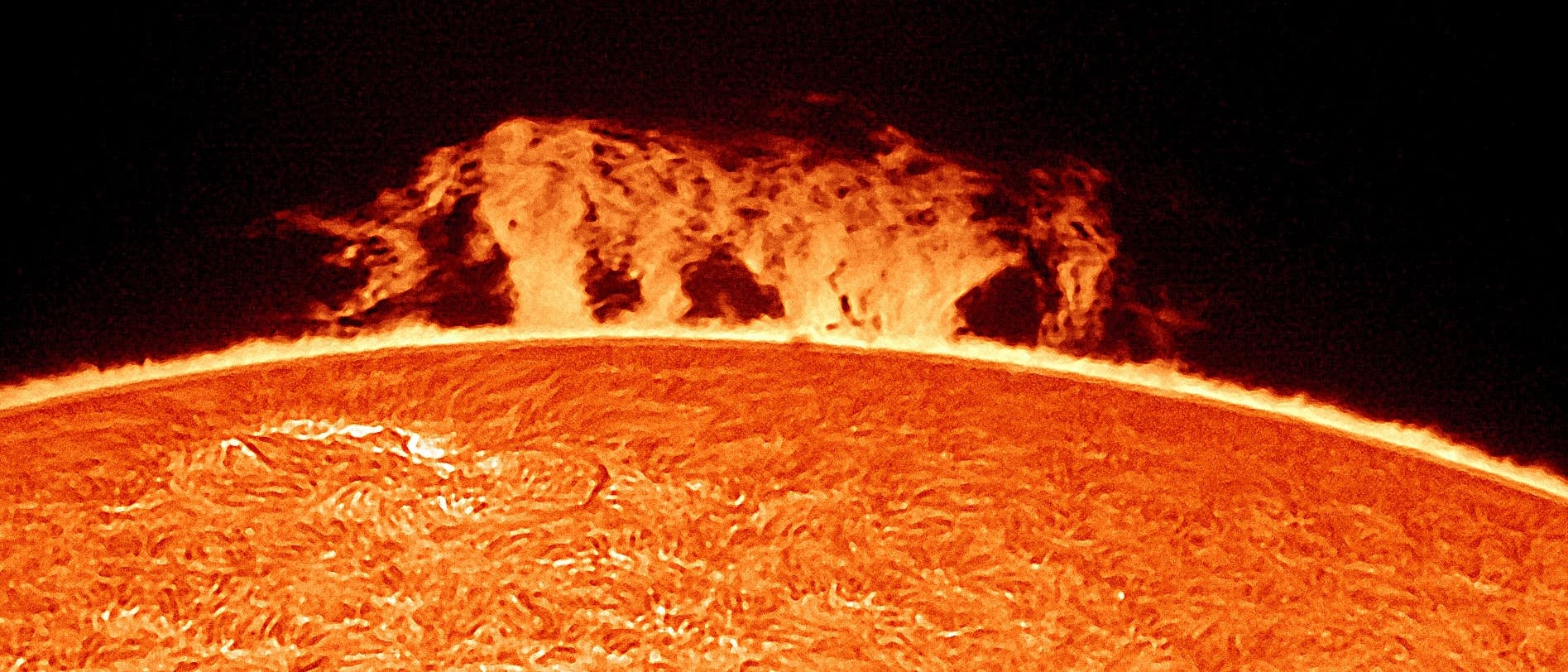 Die Abbildung zeigt eine Nahaufnahme der Sonnenoberfläche mit einer beeindruckenden Sonneneruption, die als leuchtende, flammenartige Struktur über dem Rand der Sonne sichtbar ist. Die Oberfläche der Sonne erscheint texturiert und zeigt die charakteristische Granulation. Der Hintergrund ist dunkel, was den Kontrast zur hellen Sonnenaktivität verstärkt. Schlüsselwörter: Sonne, Sonneneruption, Sonnenoberfläche, Astronomie. Die Abbildung zeigt eine Nahaufnahme der Sonnenoberfläche mit einer beeindruckenden Sonneneruption, die als leuchtende, flammenartige Struktur über dem Rand der Sonne sichtbar ist. Die Oberfläche der Sonne erscheint texturiert und zeigt die charakteristische Granulation. Der Hintergrund ist dunkel, was den Kontrast zur hellen Sonnenaktivität verstärkt. Schlüsselwörter: Sonne, Sonneneruption, Sonnenoberfläche, Astronomie.