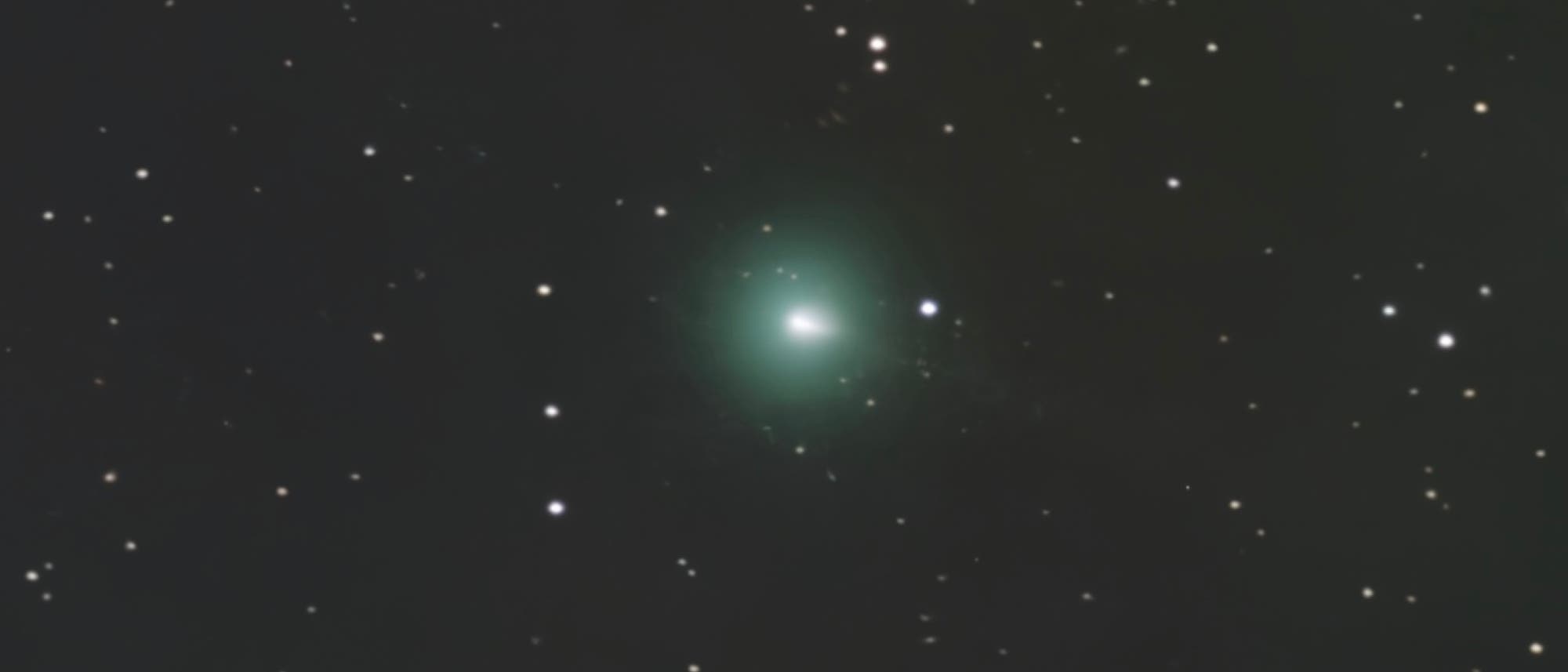 Ein astronomisches Bild zeigt einen Kometen im Weltraum. Der Komet hat einen hellen Kern mit einem grünlichen Schimmer, der von einem diffusen Schweif umgeben ist. Um den Kometen herum sind zahlreiche Sterne vor einem dunklen Hintergrund sichtbar. Das Bild vermittelt den Eindruck von Tiefe und Weite des Universums. Schlüsselwörter: Komet, Sterne, Weltraum, Astronomie. Ein astronomisches Bild zeigt einen Kometen im Weltraum. Der Komet hat einen hellen Kern mit einem grünlichen Schimmer, der von einem diffusen Schweif umgeben ist. Um den Kometen herum sind zahlreiche Sterne vor einem dunklen Hintergrund sichtbar. Das Bild vermittelt den Eindruck von Tiefe und Weite des Universums. Schlüsselwörter: Komet, Sterne, Weltraum, Astronomie.