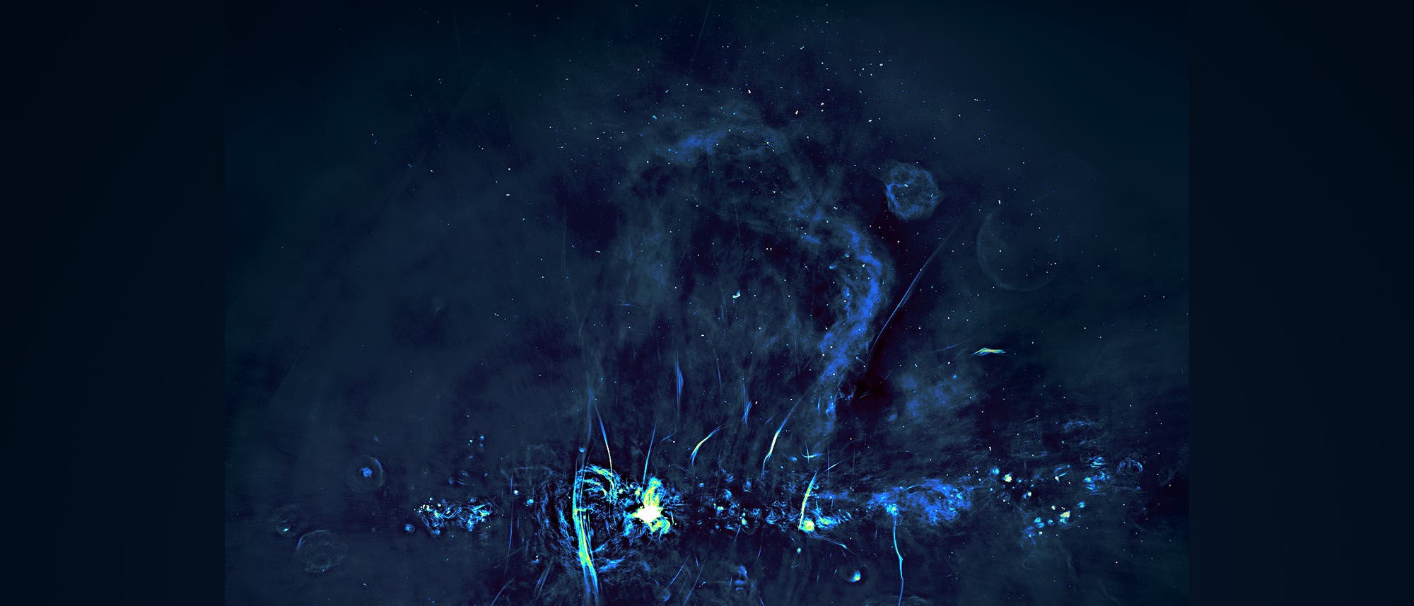 Eine astronomische Aufnahme zeigt eine komplexe Struktur im Weltraum, die in blauen und grünen Tönen leuchtet. Die Darstellung umfasst leuchtende Gaswolken und filigrane, fadenartige Strukturen, die sich durch das Bild ziehen. Im Zentrum befindet sich ein besonders heller Bereich, der möglicherweise auf eine hohe Konzentration von Energie oder Materie hinweist. Der Hintergrund ist dunkel, mit verstreuten Lichtpunkten, die Sterne oder andere Himmelskörper darstellen könnten. Eine astronomische Aufnahme zeigt eine komplexe Struktur im Weltraum, die in blauen und grünen Tönen leuchtet. Die Darstellung umfasst leuchtende Gaswolken und filigrane, fadenartige Strukturen, die sich durch das Bild ziehen. Im Zentrum befindet sich ein besonders heller Bereich, der möglicherweise auf eine hohe Konzentration von Energie oder Materie hinweist. Der Hintergrund ist dunkel, mit verstreuten Lichtpunkten, die Sterne oder andere Himmelskörper darstellen könnten.