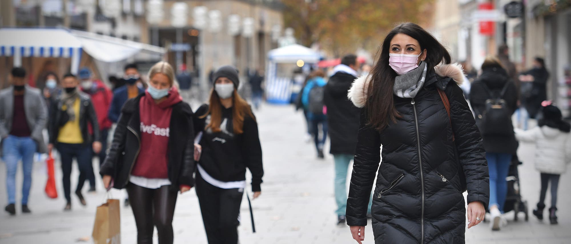 Menschen in einer Münchner Fußgängerzone tragen wegen des Coronavirus eine Maske