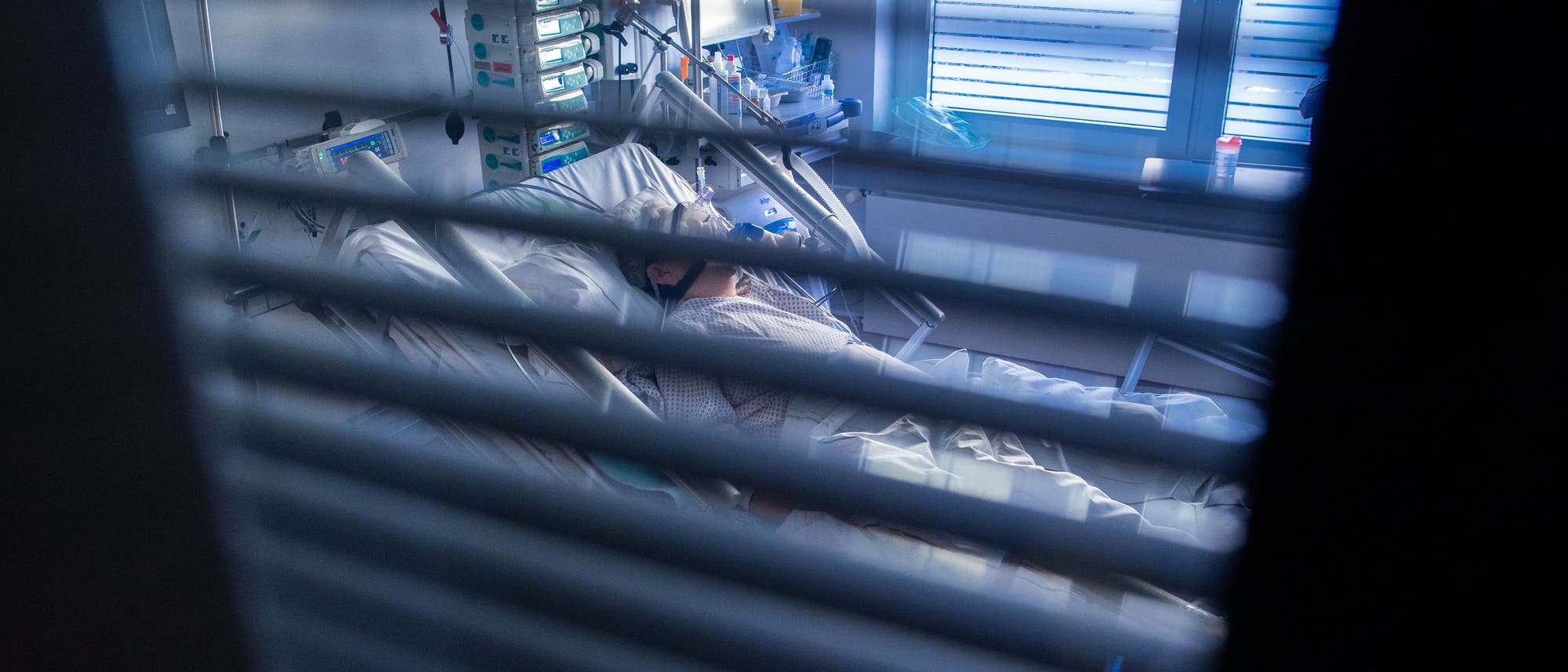 Eine an Covid-19 erkrankte Patientin liegt in einem Zimmer des besonders geschützten Teils einer Intensivstation. 