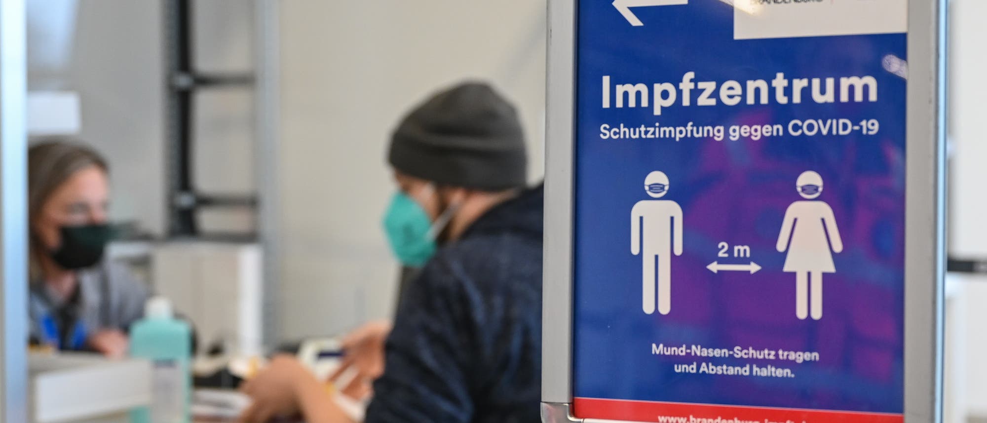 Eine Person sitzt an der Registrierung im Impfzentrum im Terminal 5 am ehemaligen Flughafen Schönefeld.