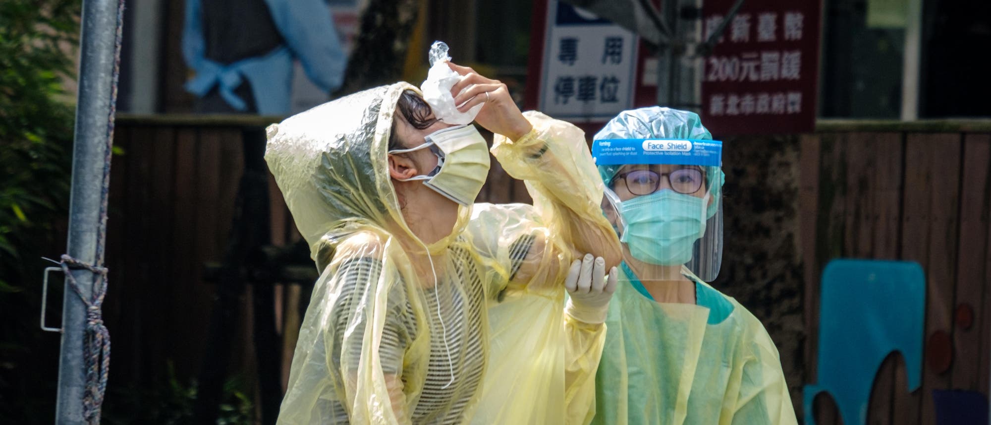 Nachdem sie in einem Testzentrum in New Taipei City auf Covid-19 getestet wurde, hält eine Person einen Eisbeutel gegen ihre Nase.