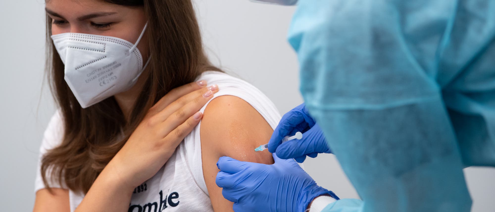 Impfung einer Schülerin einer Abschlussklasse im Impfzentrum an der Messe München