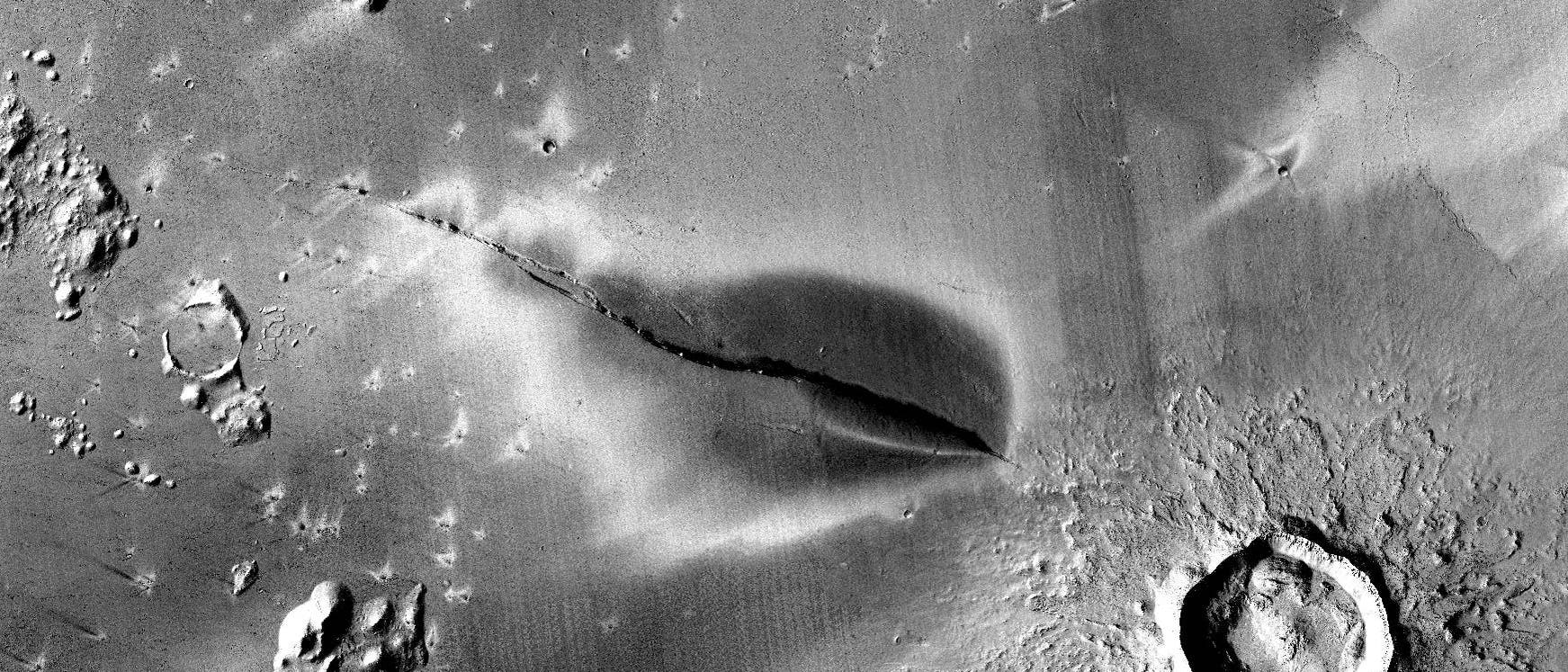 Eine dunkle Ablagerung rund um eine Spalte im Marsboden.