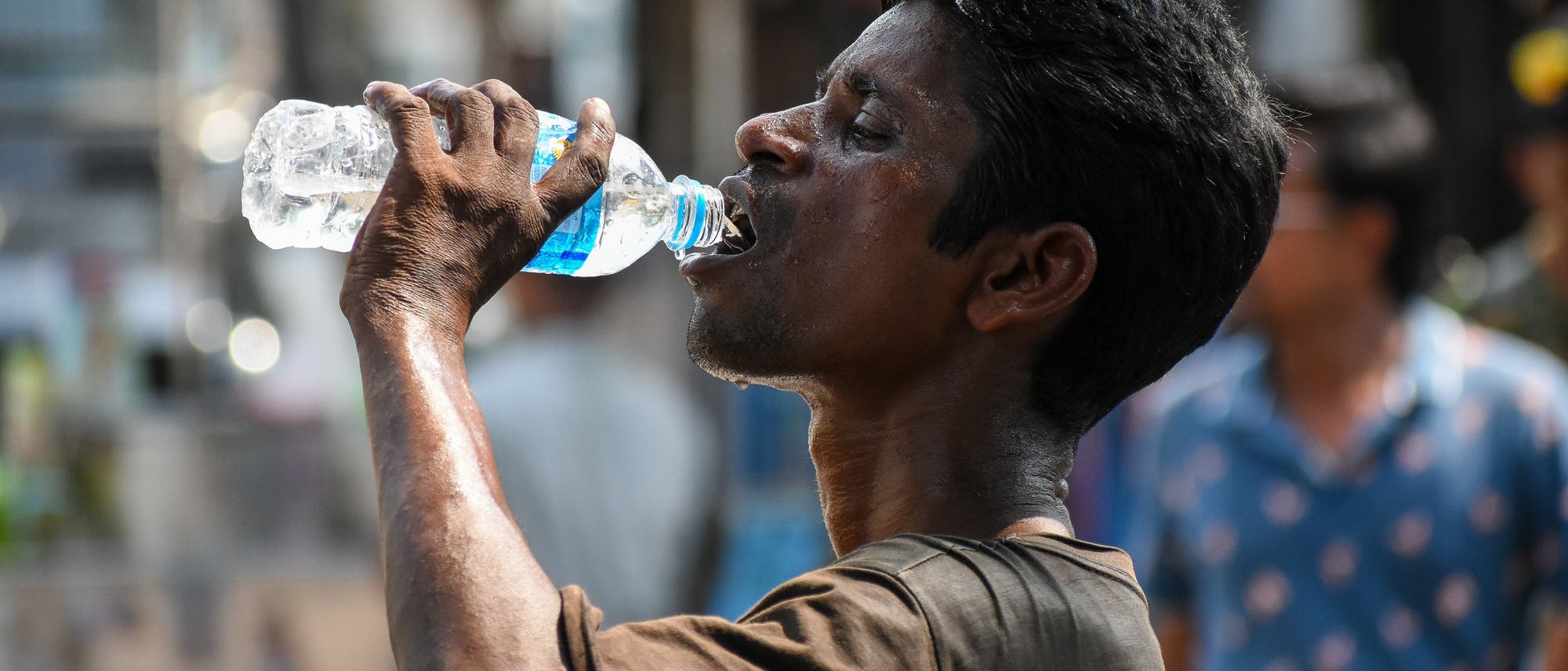 Ein Mann trinkt Wasser, um die Folgen der Hitzewelle in Indien etwas zu lindern.