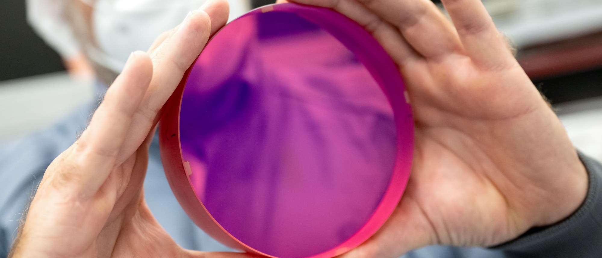 Ein Wissenschaftler hält einen Laserkristall in die Kamera