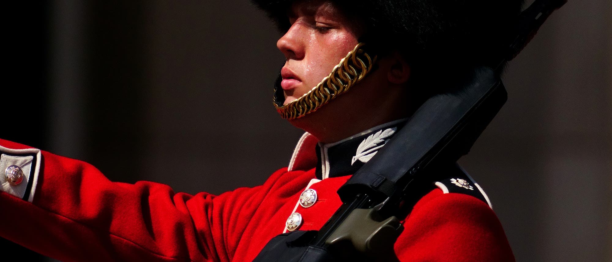 Ein Mitglied der F Company Scots Guards schwitzt in der Hitze während der Zeremonie des Wachwechsels auf dem Vorplatz des Buckingham Palace im Zentrum von London.