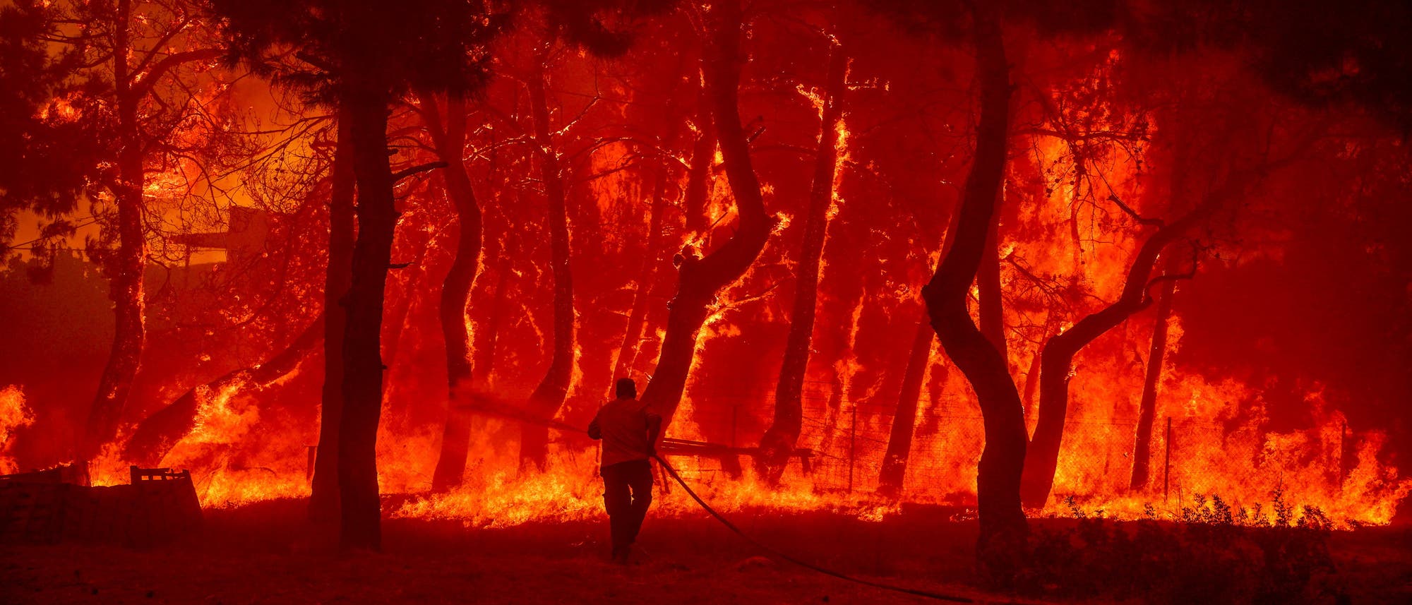 Ein Feuerwehrmann rückt im Juli 2022 mit dem Schlauch gegen einen Waldbrand auf Lesbos an.