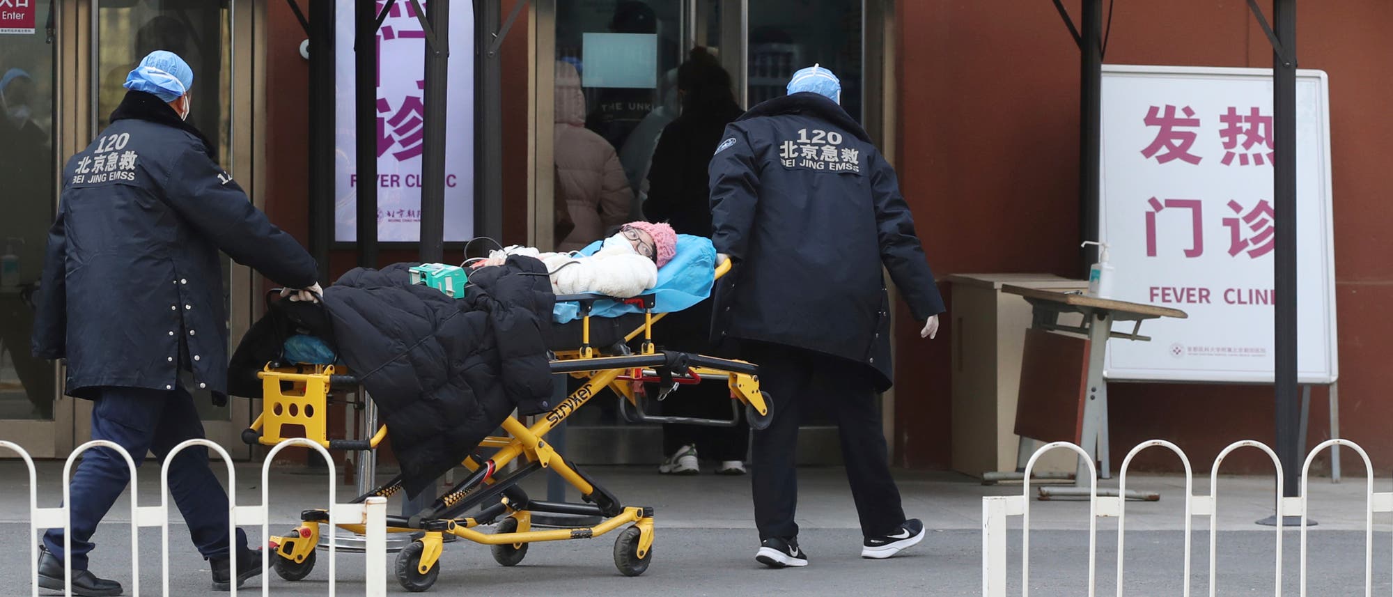Eine Patientin wird in China in eine Fieberklinik gebracht.