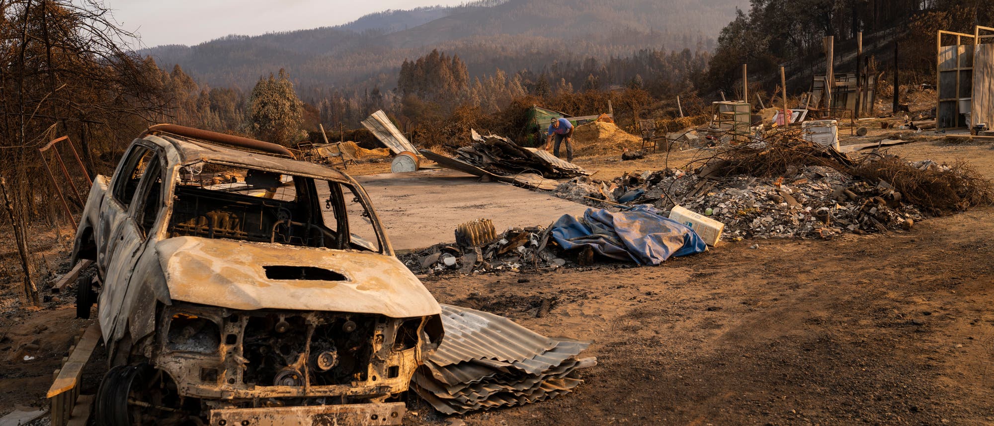 Ein zerstörtes Auto ist die Folge eines Waldbrandes in Chile.