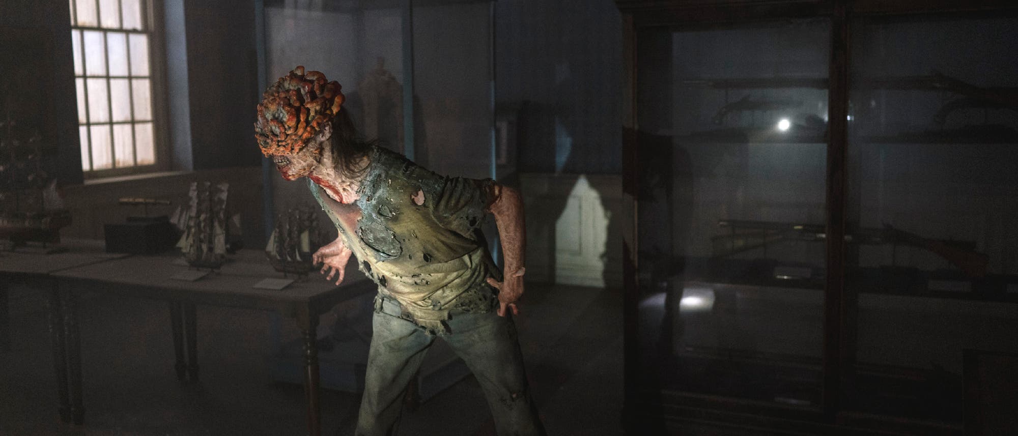 Ein Szenenbild aus der Fernsehserie "The Last of Us". Ein Infizierter sieht gefährlich aus.