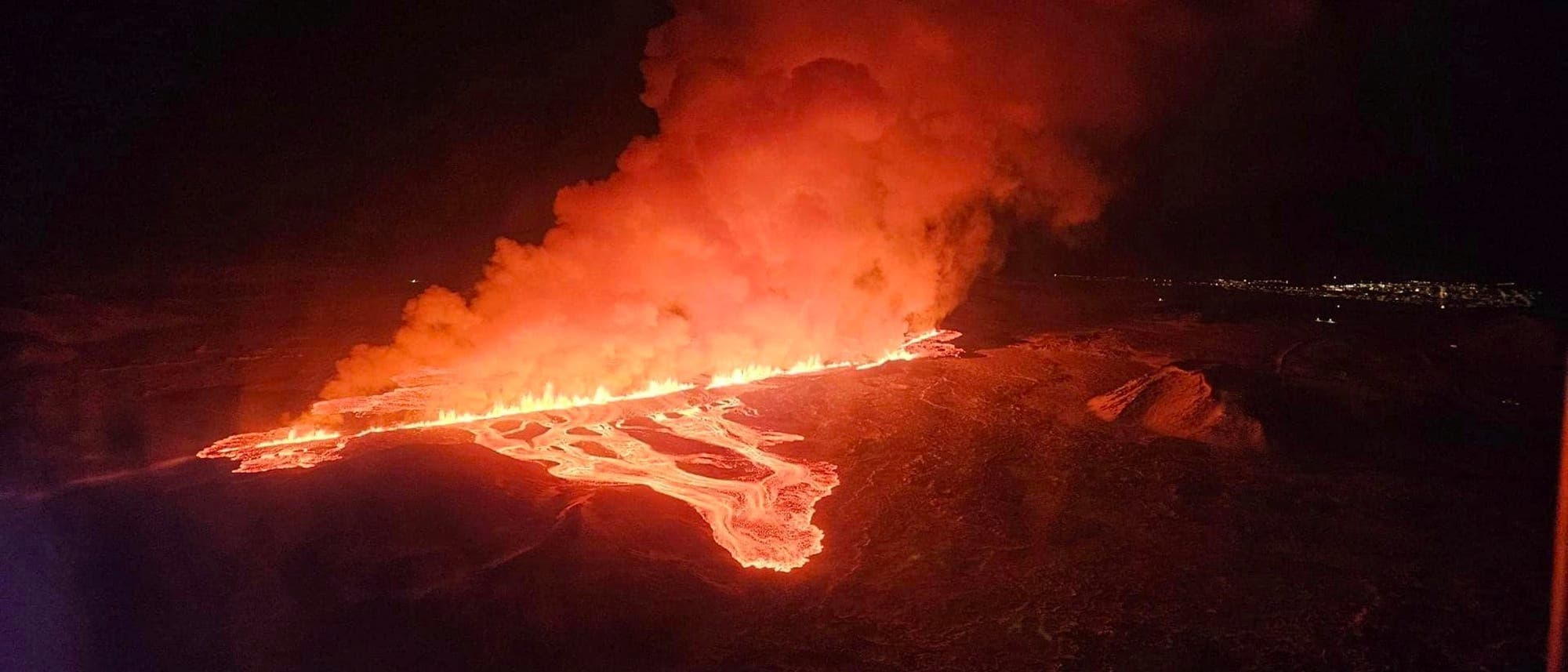Ausbruch auf der Reykjanes-Halbinsel auf Island am 8. Februar 2024: Glühende Lava strömt in der Nacht aus einem Riss in der Erde.