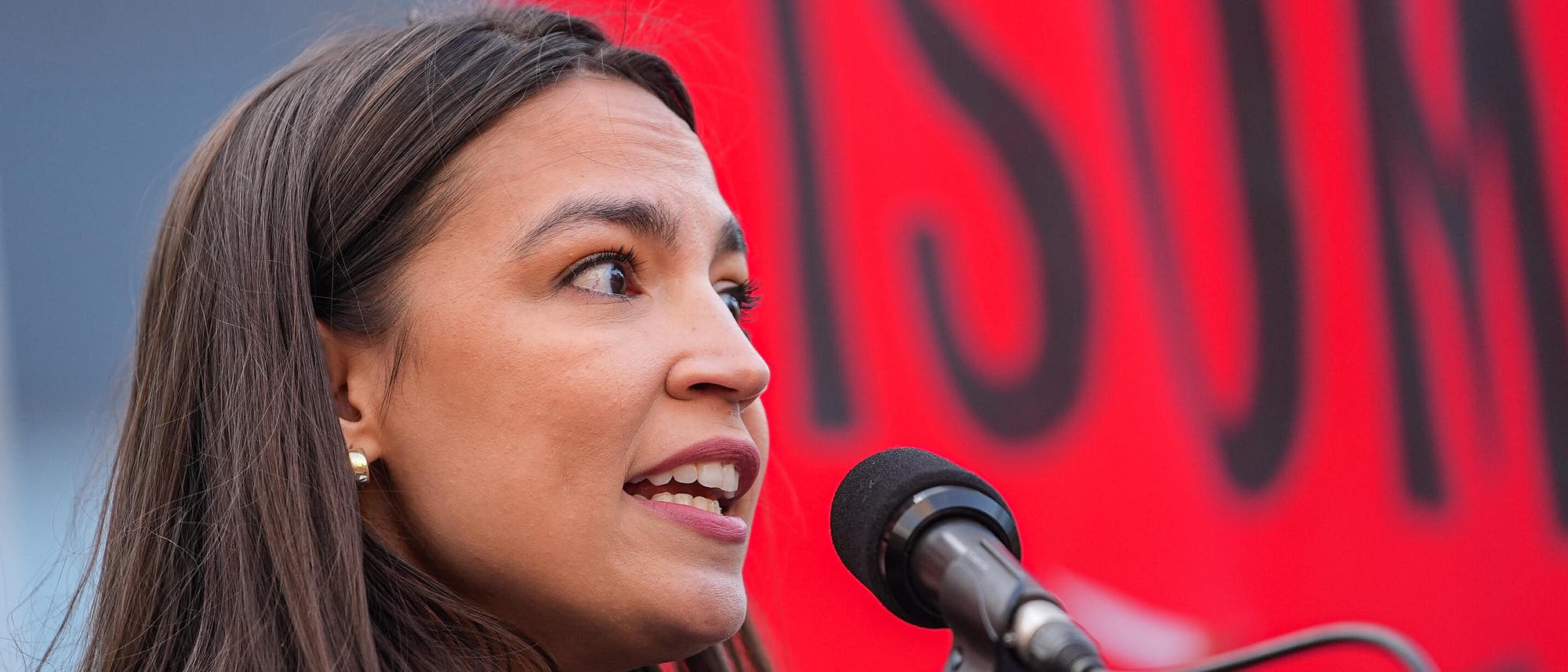 Die Politikerin Alexandria Ocasio-Cortez bei einer Kundgebung am Mikrofon. Die Politikerin Alexandria Ocasio-Cortez bei einer Kundgebung am Mikrofon.