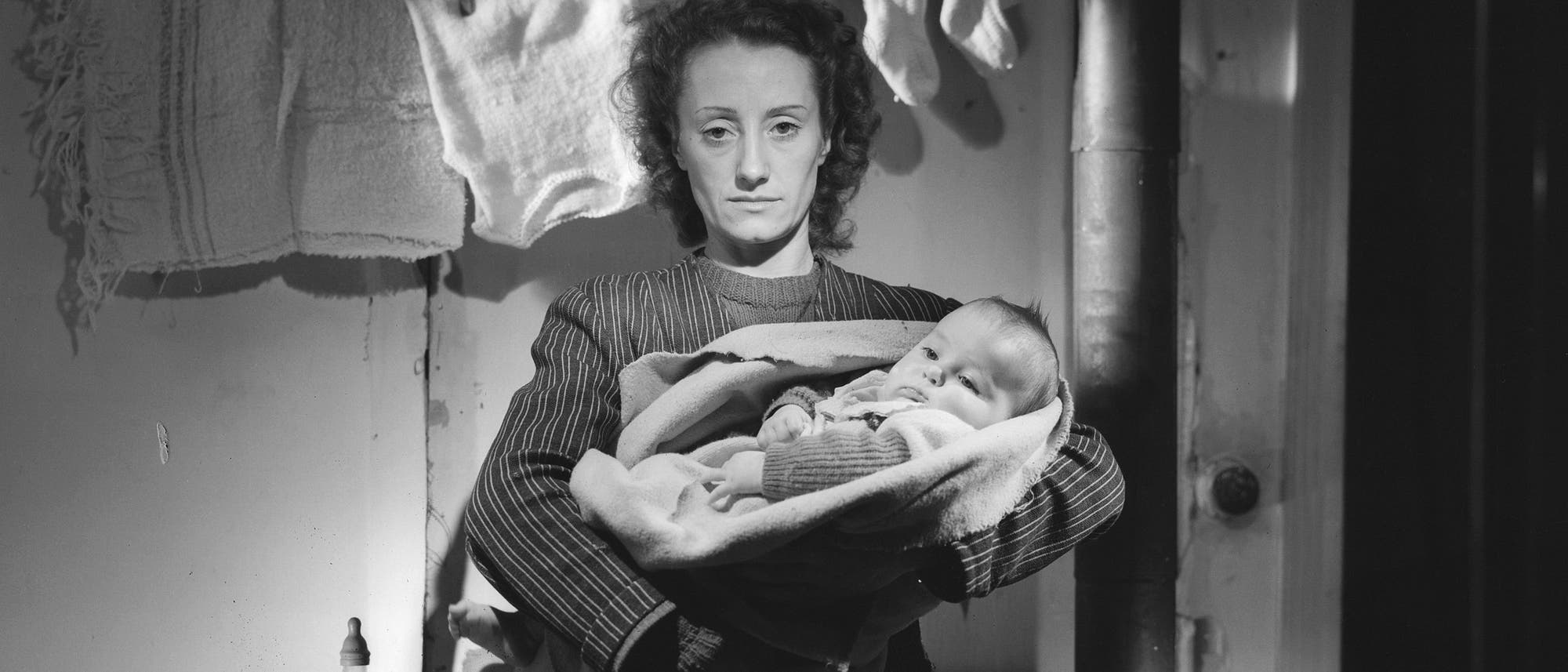 Eine Mutter hält ihr Baby auf dem Arm, Schwarz-Weiß-Aufnahme Eine Mutter hält ihr Baby auf dem Arm, Schwarz-Weiß-Aufnahme