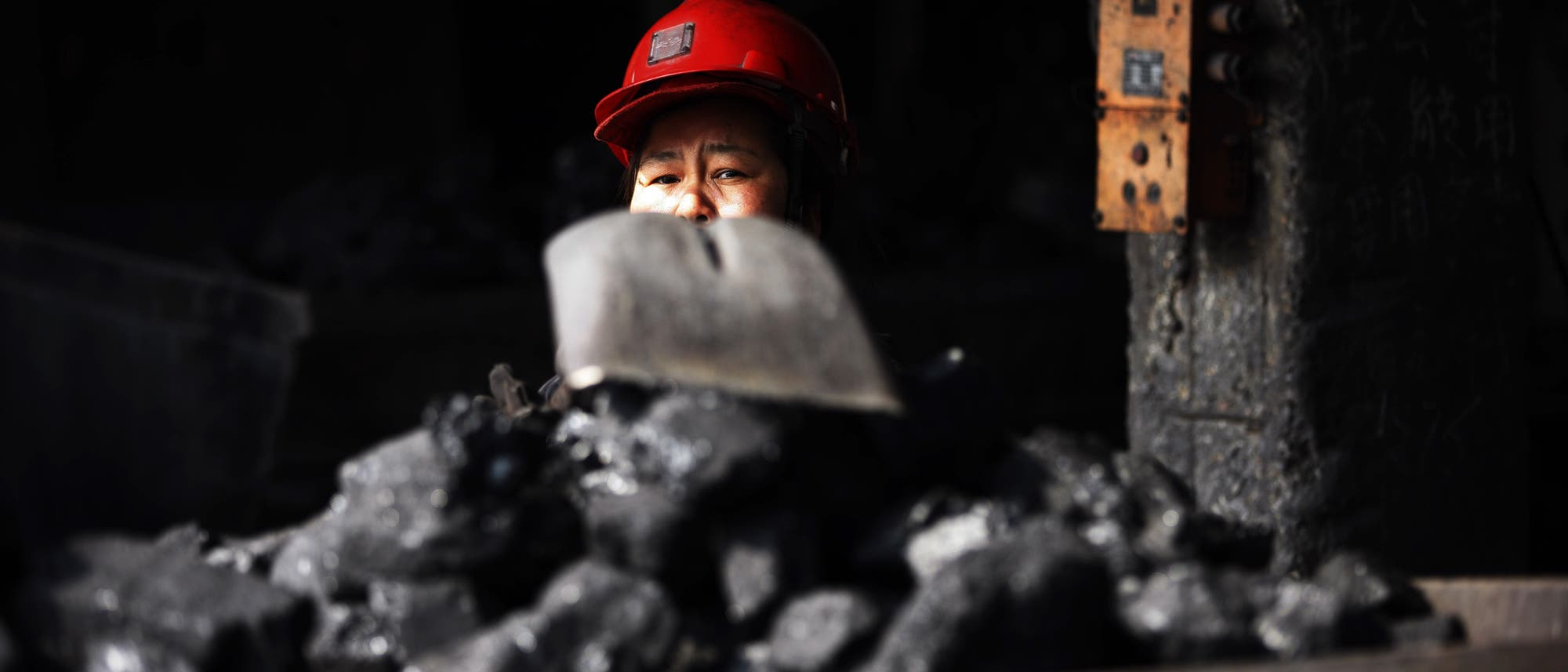 Ein chinesischer Arbeiter belädt einen Grubenwagen mit Kohle in einem Kohlebergwerk in der Stadt Huaibei in der ostchinesischen Provinz Anhui (Archiv).