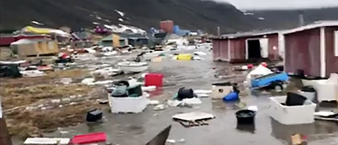 Beschädigte Häuser und Trümmer stehen im Wasser. Videobild vom Tsunami in Nuugaatsiaq