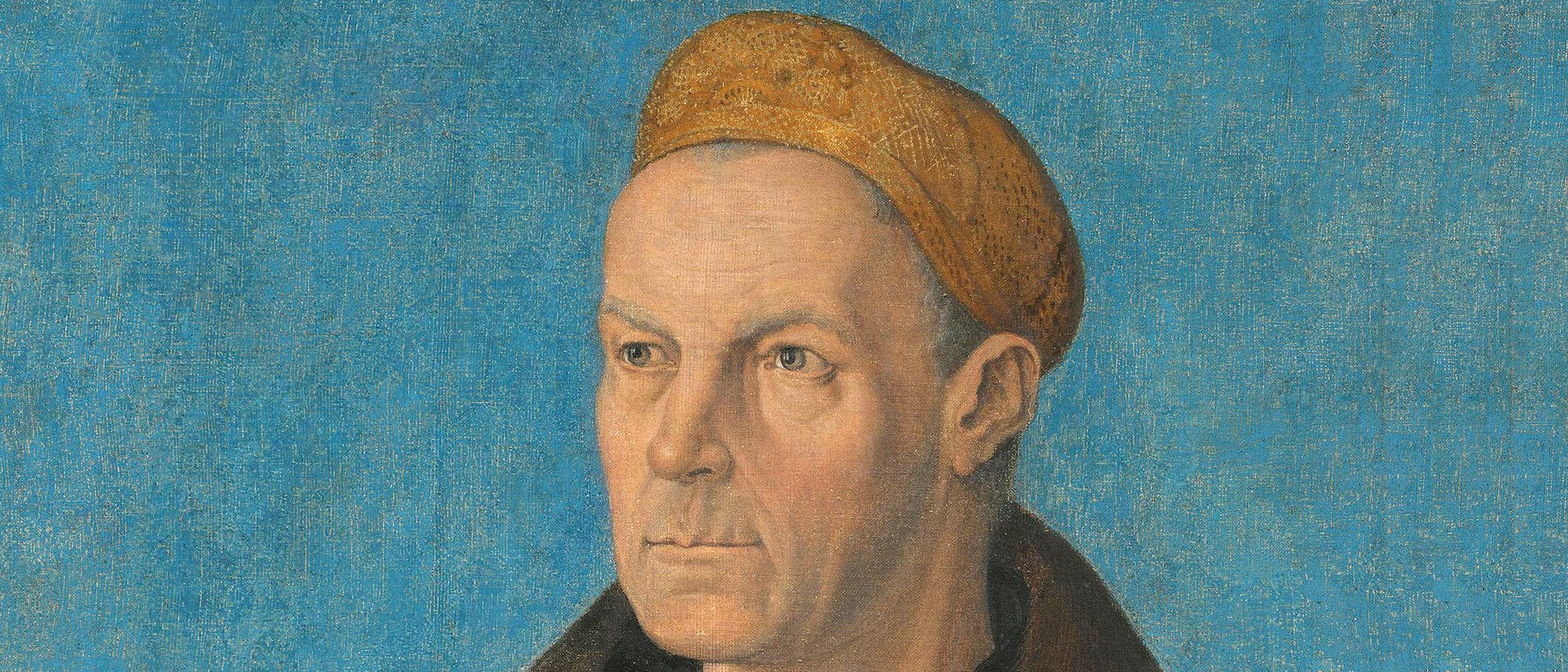 Ein Portr&auml;t eines Mannes vor einem blauen Hintergrund. Der Mann tr&auml;gt ein dunkles Gewand und eine braune Kopfbedeckung. Der Ausdruck ist ernst und nachdenklich. Die Maltechnik zeigt feine Details und eine realistische Darstellung. Das Bild vermittelt einen klassischen, zeitlosen Eindruck.