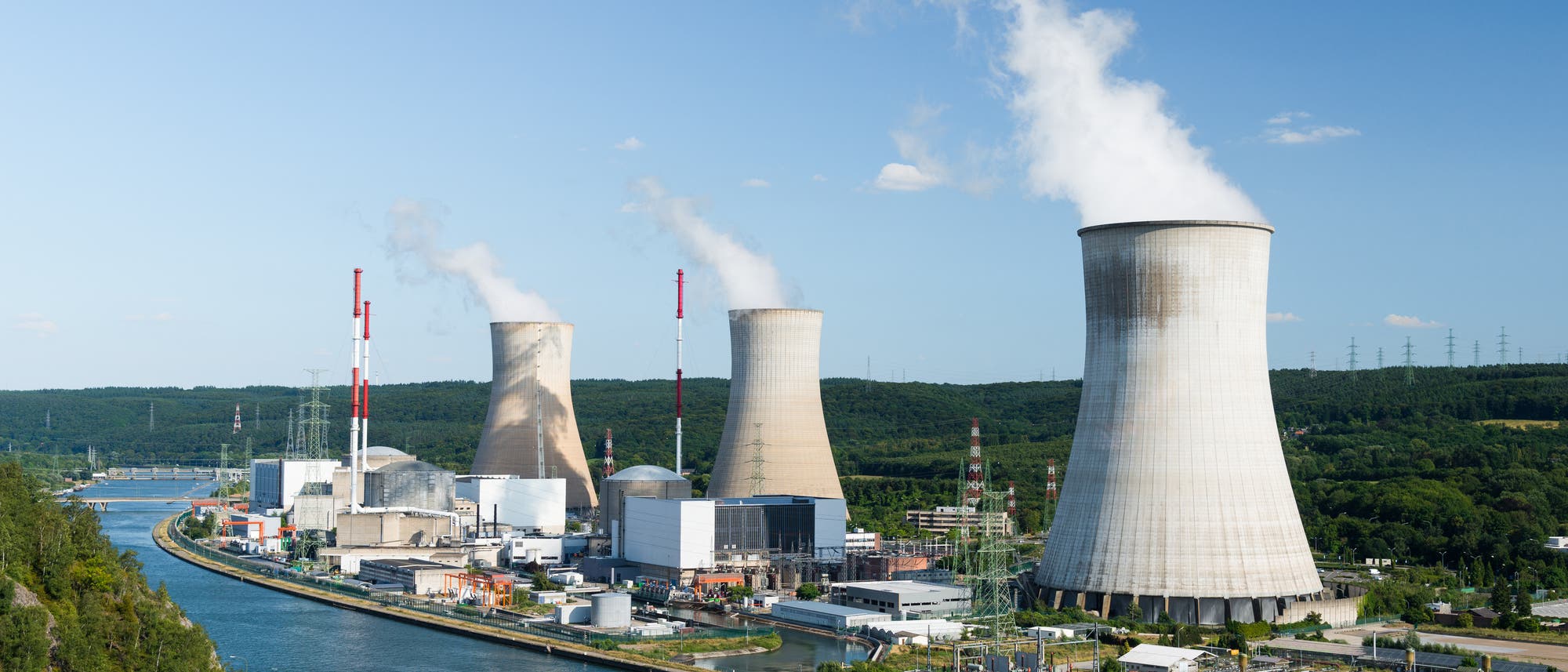 Ein Atomkraftwerk mit Kühltürmen in einer Flussbiegung