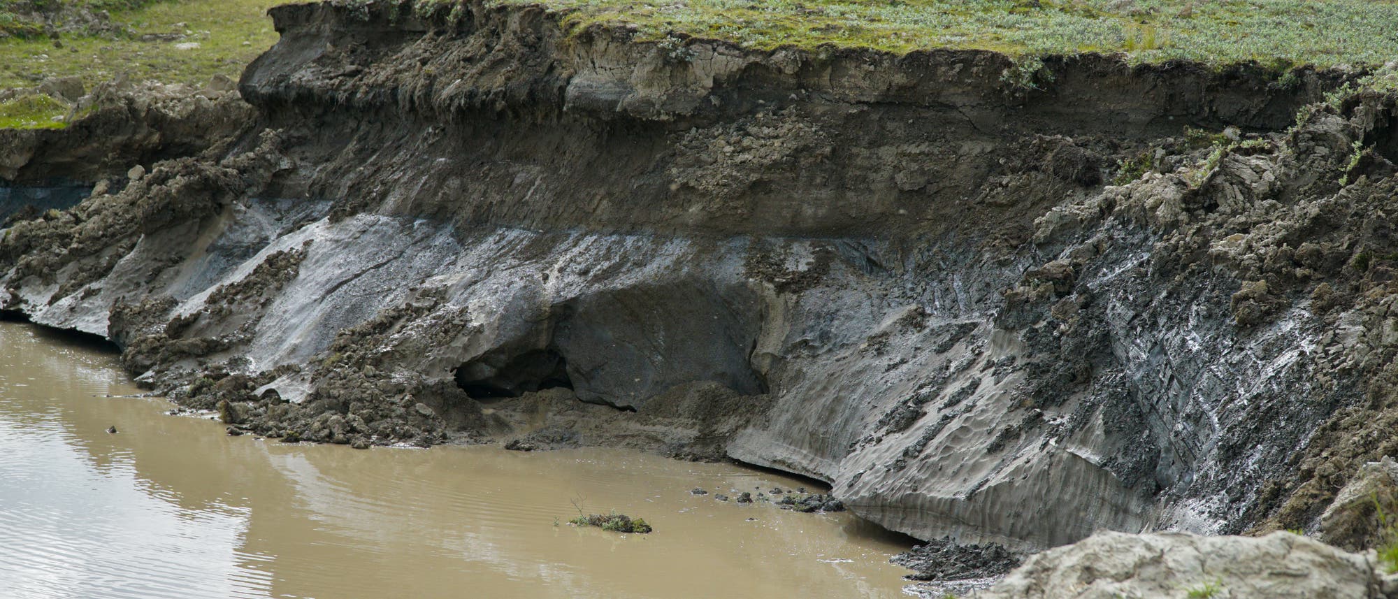 Die Steilwand eines Kraters in Sibirien, der vermutlich von einer geschmolzenen Eislinse hinterlassen wurde. In der Steilwand erkennt man noch die Permafrost-Schichten.