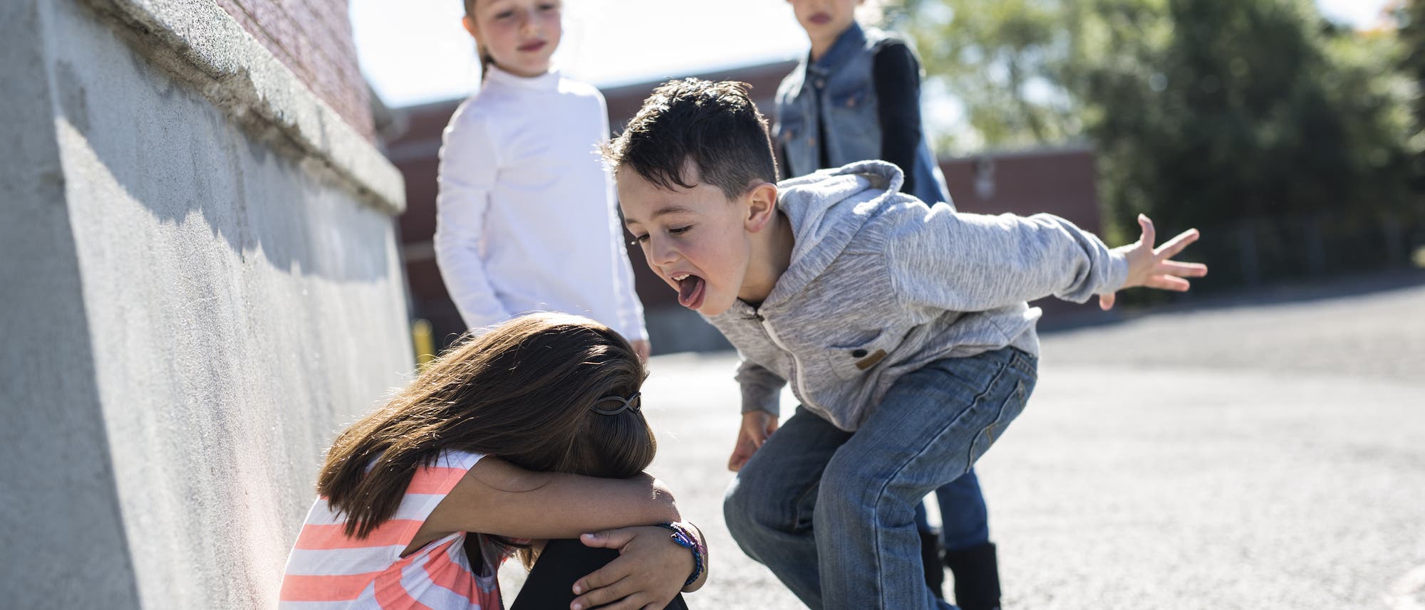 Eine Gruppe Schüler mobbt ein Mädchen 