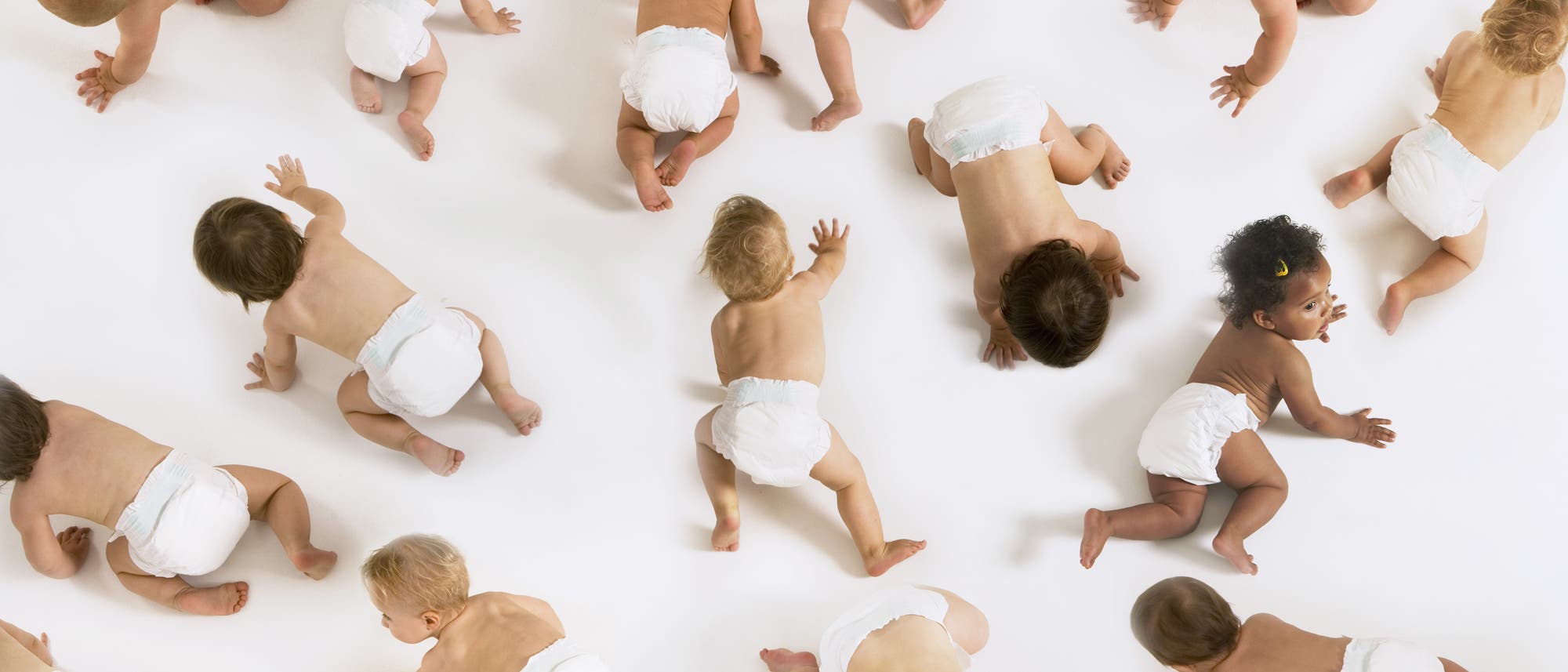 Babys krabbeln auf einem weißen Fußboden.