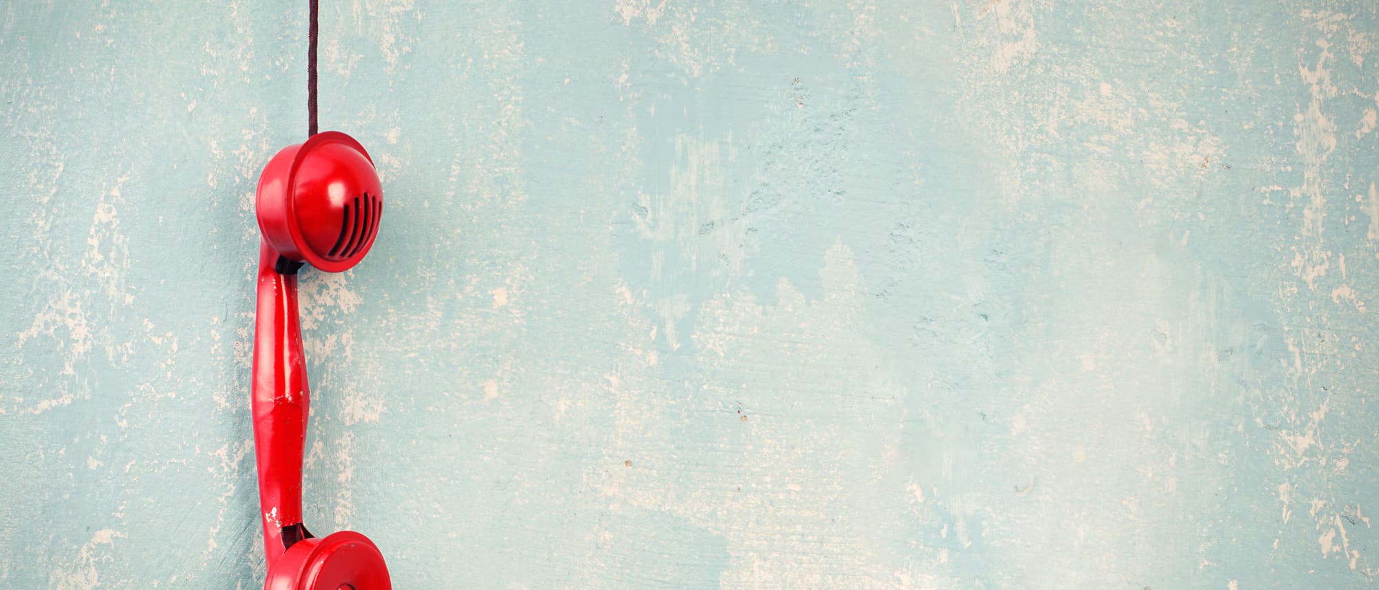 Ein roter Telefonhörer hängt in der Luft Ein roter Telefonhörer hängt in der Luft