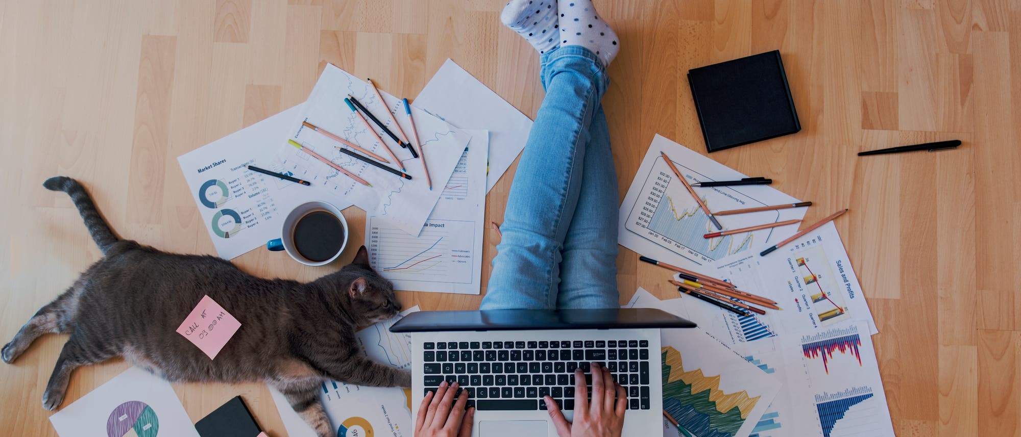 Eine Person sitzt auf dem Fu&szlig;boden und arbeitet