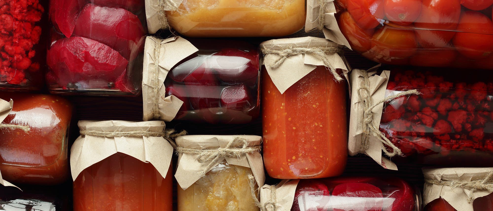 Eine Sammlung von Einmachgläsern, die verschiedene eingelegte und konservierte Lebensmittel enthalten. 