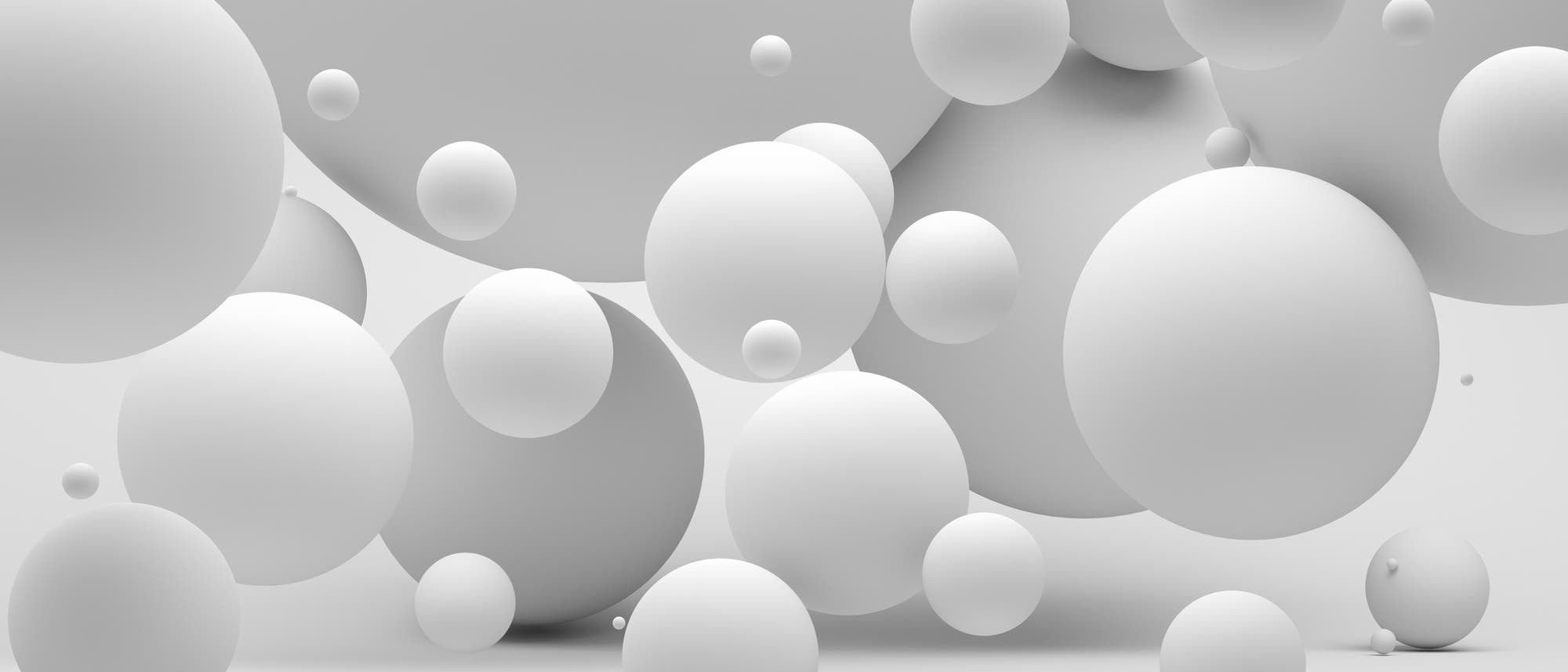 Eine 3D-Darstellung zeigt eine Vielzahl von schwebenden, unterschiedlich großen weißen Kugeln vor einem neutralen Hintergrund. Die Kugeln überlappen sich teilweise und erzeugen einen Eindruck von Tiefe und Raum. Die Anordnung der Kugeln vermittelt ein Gefühl von Leichtigkeit und Bewegung. Eine 3D-Darstellung zeigt eine Vielzahl von schwebenden, unterschiedlich großen weißen Kugeln vor einem neutralen Hintergrund. Die Kugeln überlappen sich teilweise und erzeugen einen Eindruck von Tiefe und Raum. Die Anordnung der Kugeln vermittelt ein Gefühl von Leichtigkeit und Bewegung.