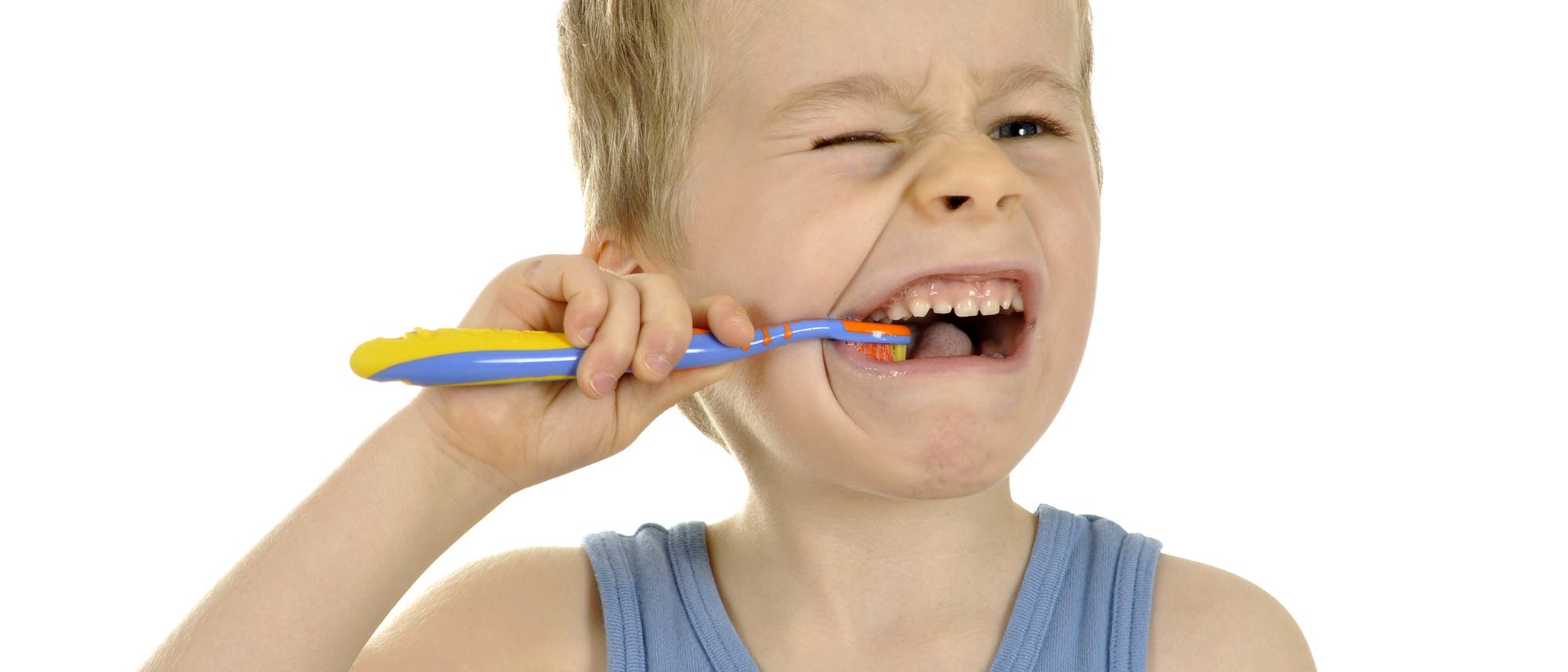 Ein kleiner Junge beim Zähneputzen vor weißem Hintergrund