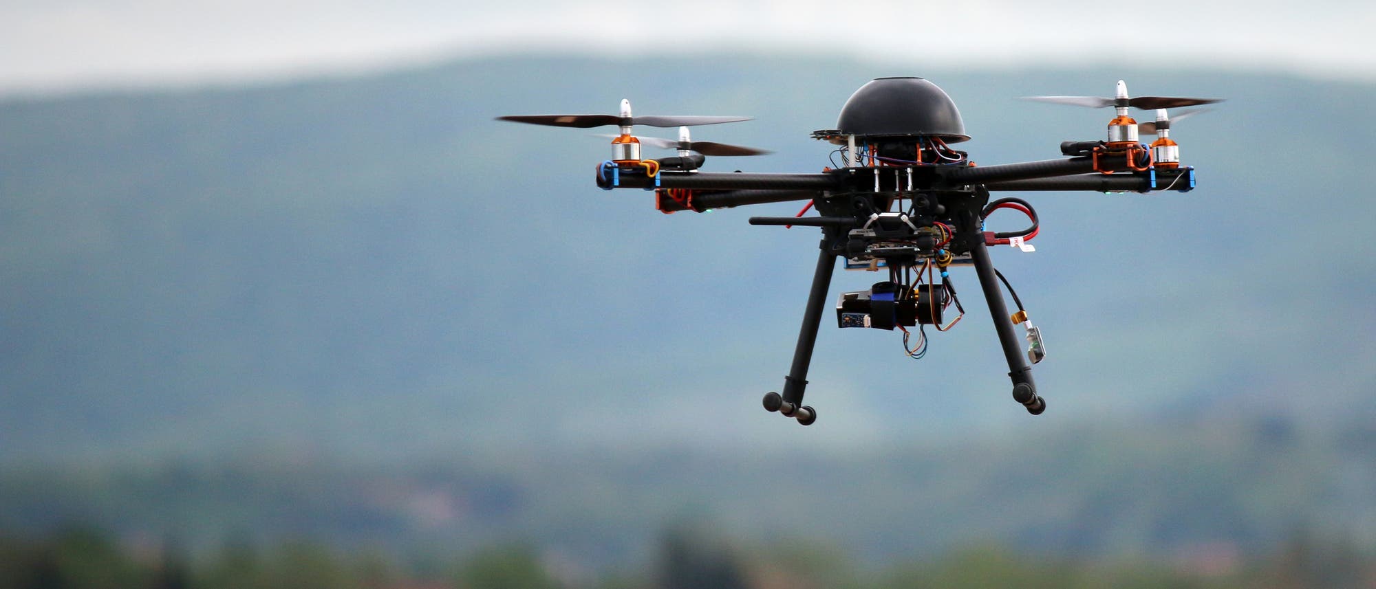 Eine Drohne im Flug vor Landschaft