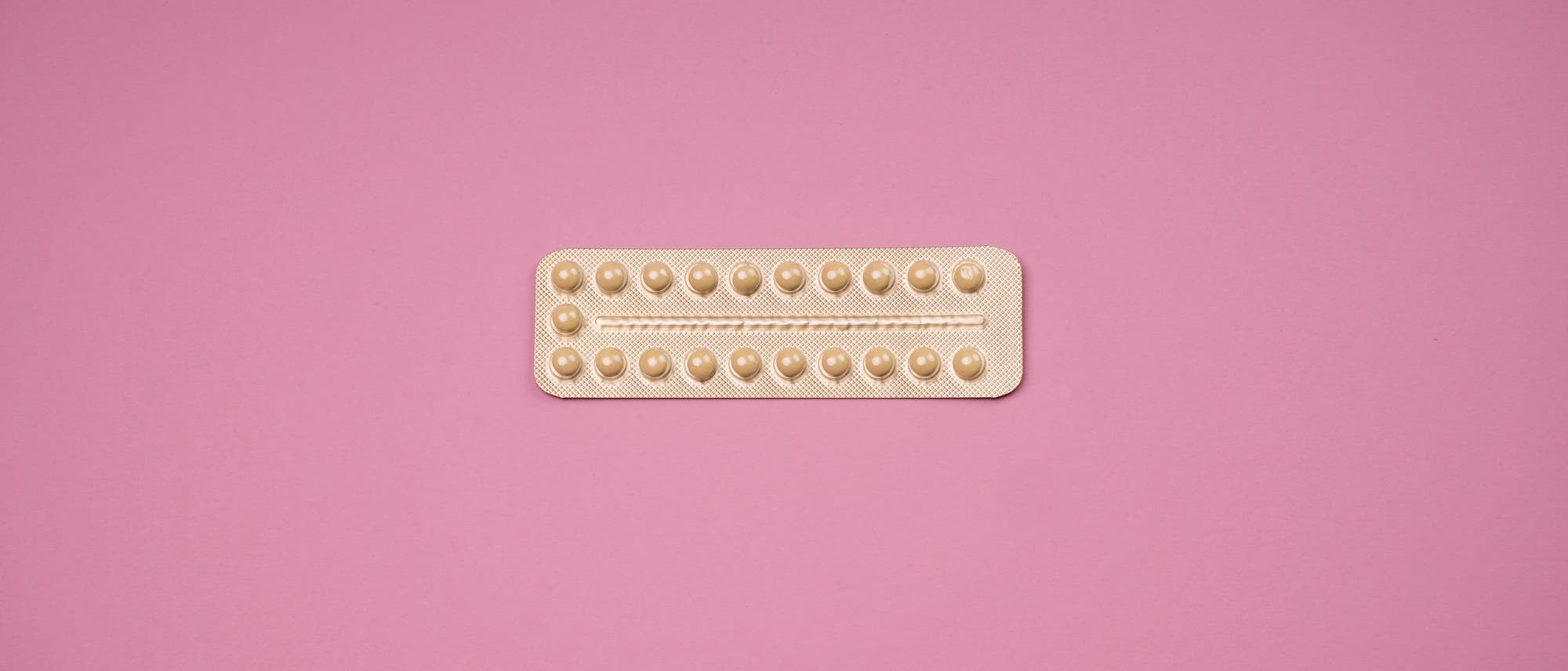 Blisterpackung für die Pille vor rosafarbenem Hintergrund