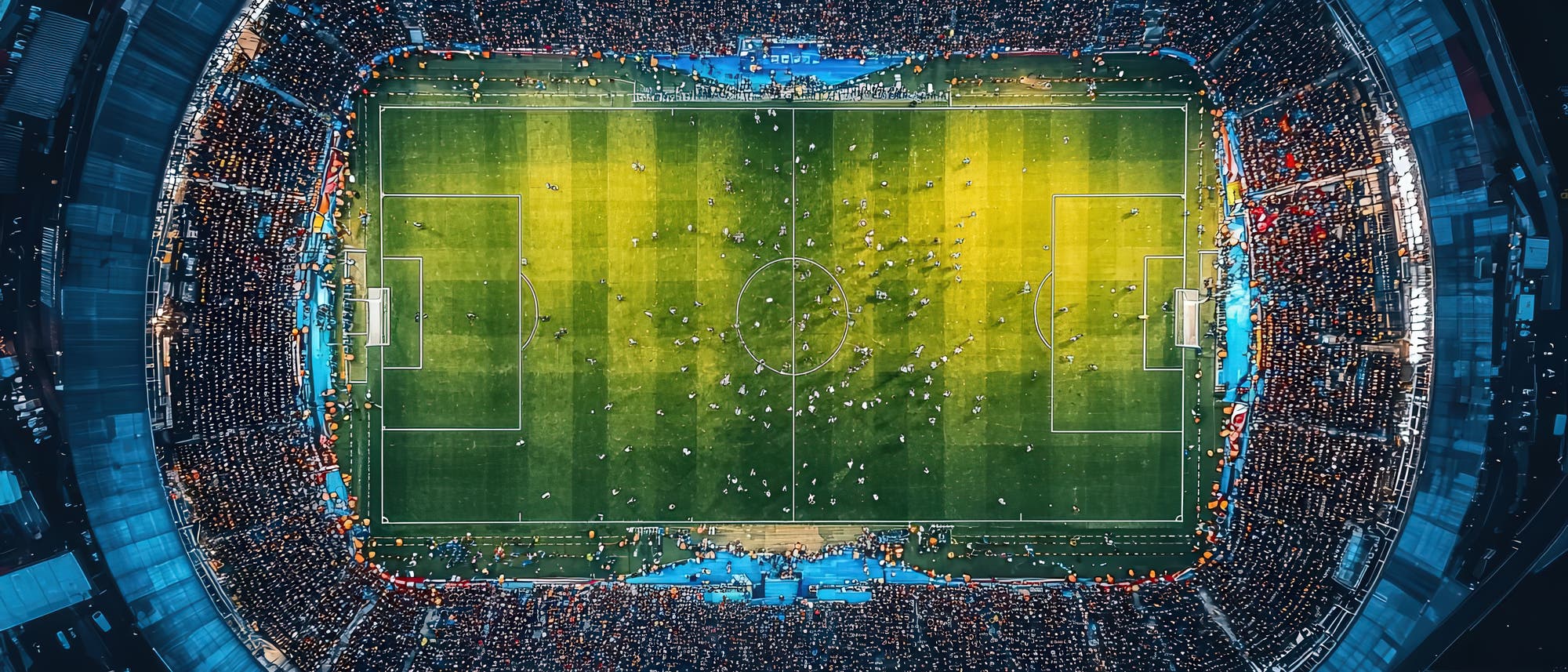 Luftaufnahme eines voll besetzten Fu&szlig;ballstadions w&auml;hrend eines Spiels. Das Spielfeld ist von hellen Flutlichtern beleuchtet, und Spieler sind in Aktion zu sehen. 