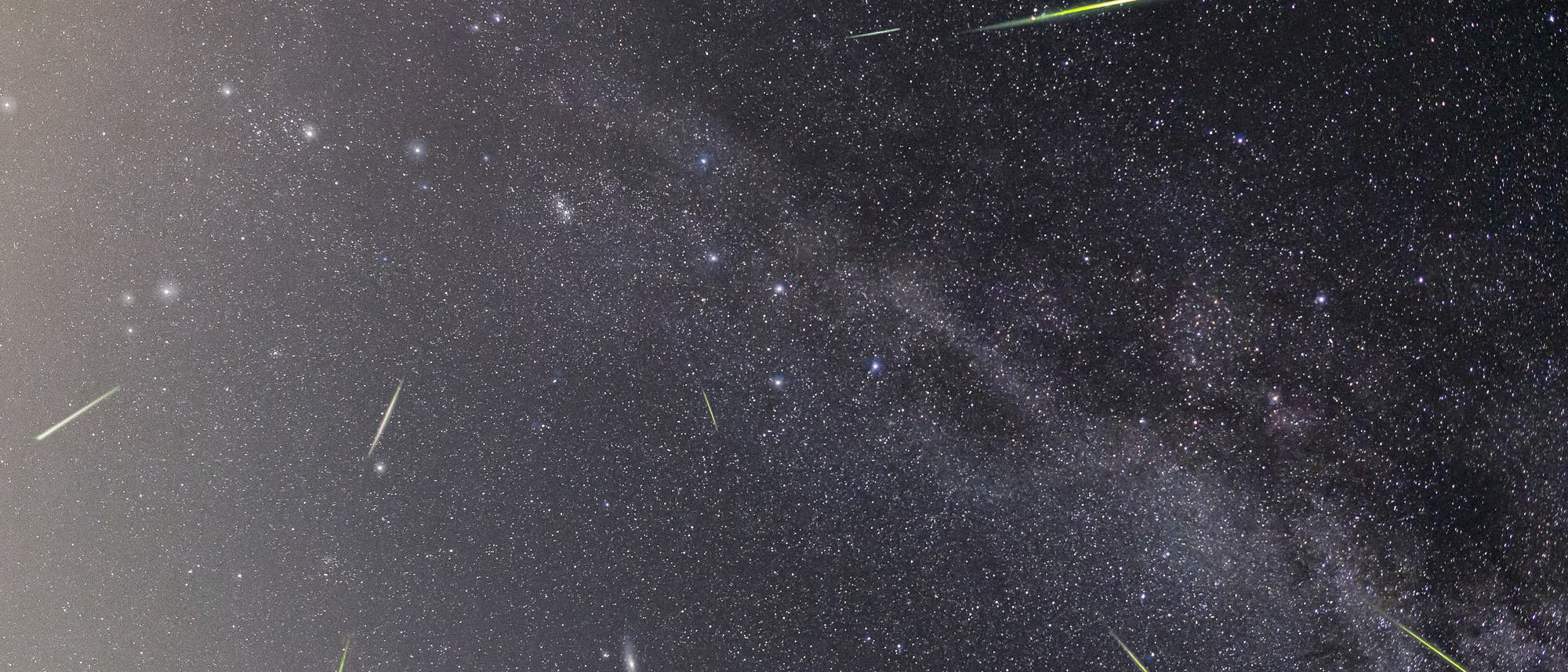 Sternenbedeckter Nachthimmel mit mehreren Meteoren, die als helle, leuchtende Streifen erscheinen. Die Milchstra&szlig;e ist als nebliges Band sichtbar, das sich diagonal &uuml;ber das Bild erstreckt. Die Meteore variieren in Helligkeit und Richtung, was auf einen Meteorstrom hindeutet. Der Himmel ist klar und voller Sterne unterschiedlicher Helligkeit.