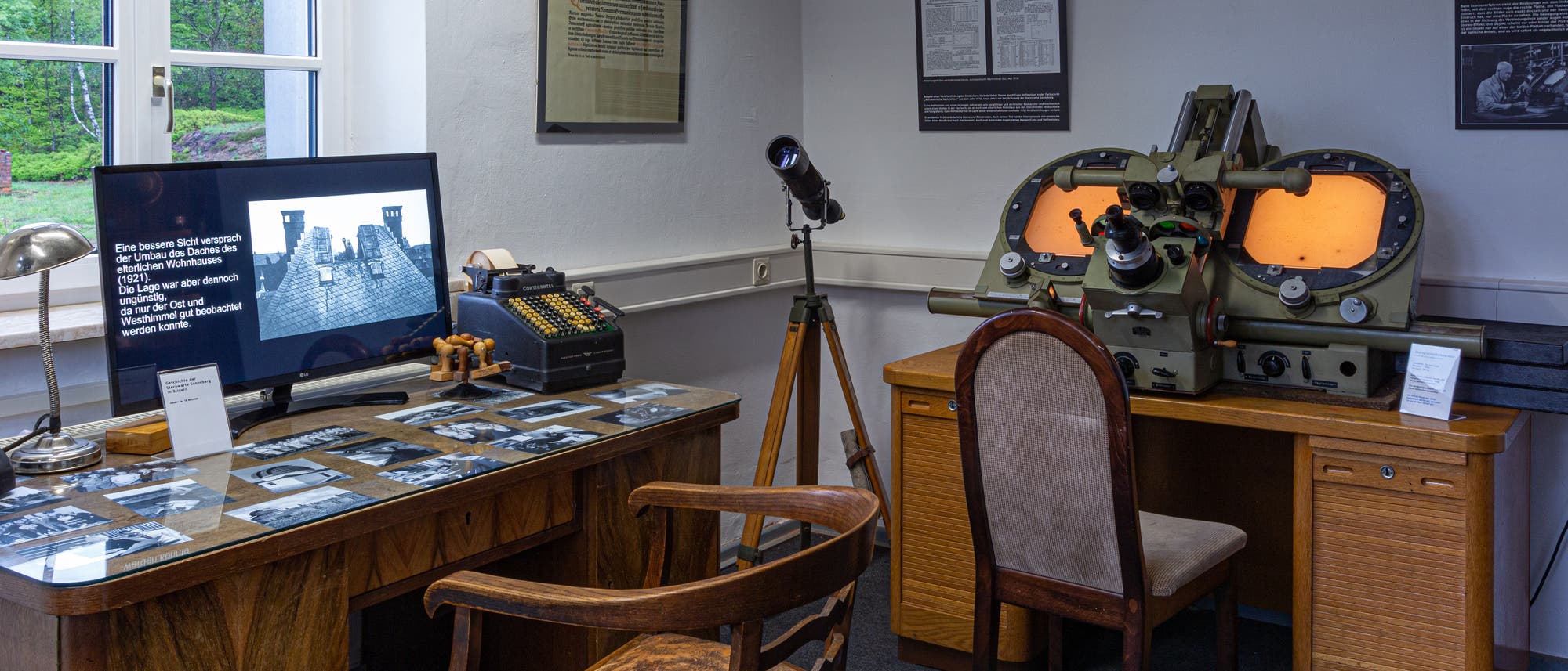 In einem Ausstellungsraum sind historische Möbel und astronomische Geräte zu sehen, die der erste Direktor der Sternwarte Sonneberg, Cuno Hoffmeister, verwendet hatte. Links steht sein Schreibtisch mit einem alten Bürostuhl, in der Mitte ein Linsenfernrohr und rechts ein Blinkkomparator, eine Messeinrichtung, um veränderliche Himmelsquellen aufzufinden. Davor steht ebenfalls ein alter Stuhl, der wahrscheinlich nicht zur damaligen Einrichtung gehörte. Der Flachbildschirm auf dem Tisch gehörte ebenfalls nicht zur ursprünglichen Ausstattung. Der Raum ist gut beleuchtet und hat eine professionelle Atmosphäre. In einem Ausstellungsraum sind historische Möbel und astronomische Geräte zu sehen, die der erste Direktor der Sternwarte Sonneberg, Cuno Hoffmeister, verwendet hatte. Links steht sein Schreibtisch mit einem alten Bürostuhl, in der Mitte ein Linsenfernrohr und rechts ein Blinkkomparator, eine Messeinrichtung, um veränderliche Himmelsquellen aufzufinden. Davor steht ebenfalls ein alter Stuhl, der wahrscheinlich nicht zur damaligen Einrichtung gehörte. Der Flachbildschirm auf dem Tisch gehörte ebenfalls nicht zur ursprünglichen Ausstattung. Der Raum ist gut beleuchtet und hat eine professionelle Atmosphäre.