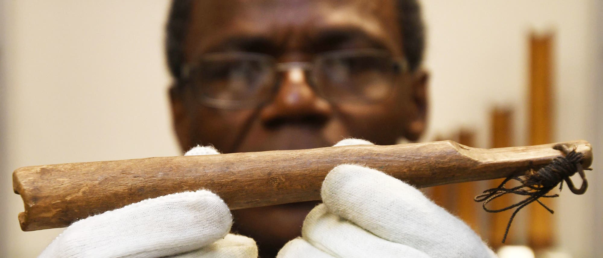 Der Wissenschaftler Ndzodo Awono zeigt im Schaumagazin des Bremer Überseemuseums eine Pfeife aus Kamerun