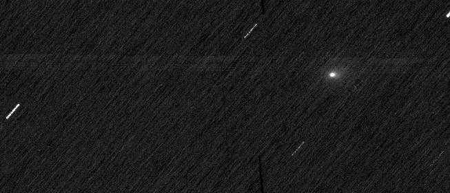 Ein astronomisches Bild zeigt einen dunklen Nachthimmel mit mehreren diagonalen, hellen Streifen, die auf Sternspuren hindeuten. Ein besonders heller Punkt in der Mitte könnte ein Planet oder ein heller Stern sein. Die Streifen entstehen durch die Bewegung der Himmelskörper während einer Langzeitbelichtung. Das Bild vermittelt den Eindruck von Bewegung und Tiefe im Weltraum.