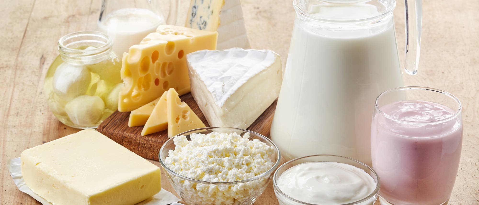 Milch, Käse, Joghurt und Co, drapiert auf einem Holztisch
