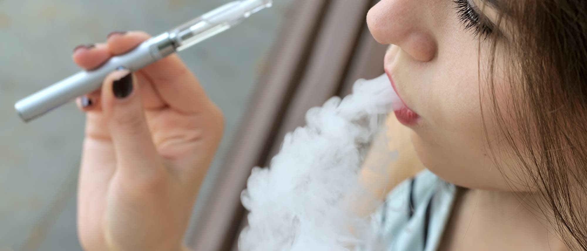 Eine junge Frau raucht eine E-Zigarette