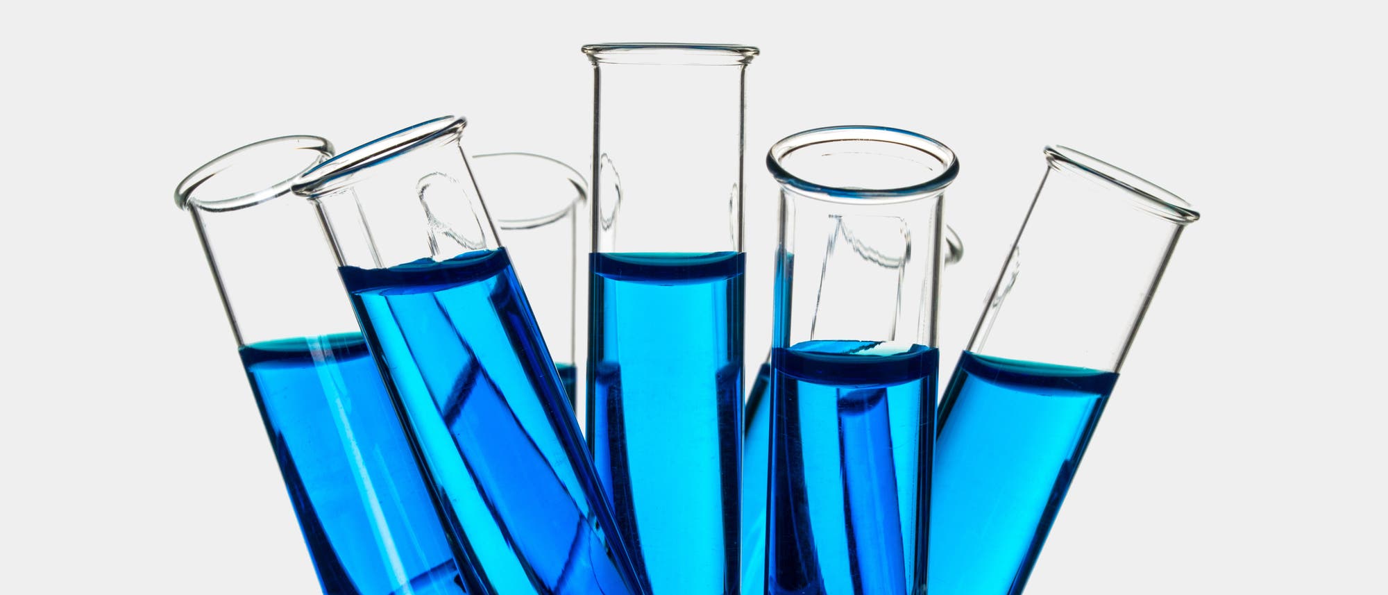 Reagenzgläser mit blauer Lösung in einem großen Becherglas
