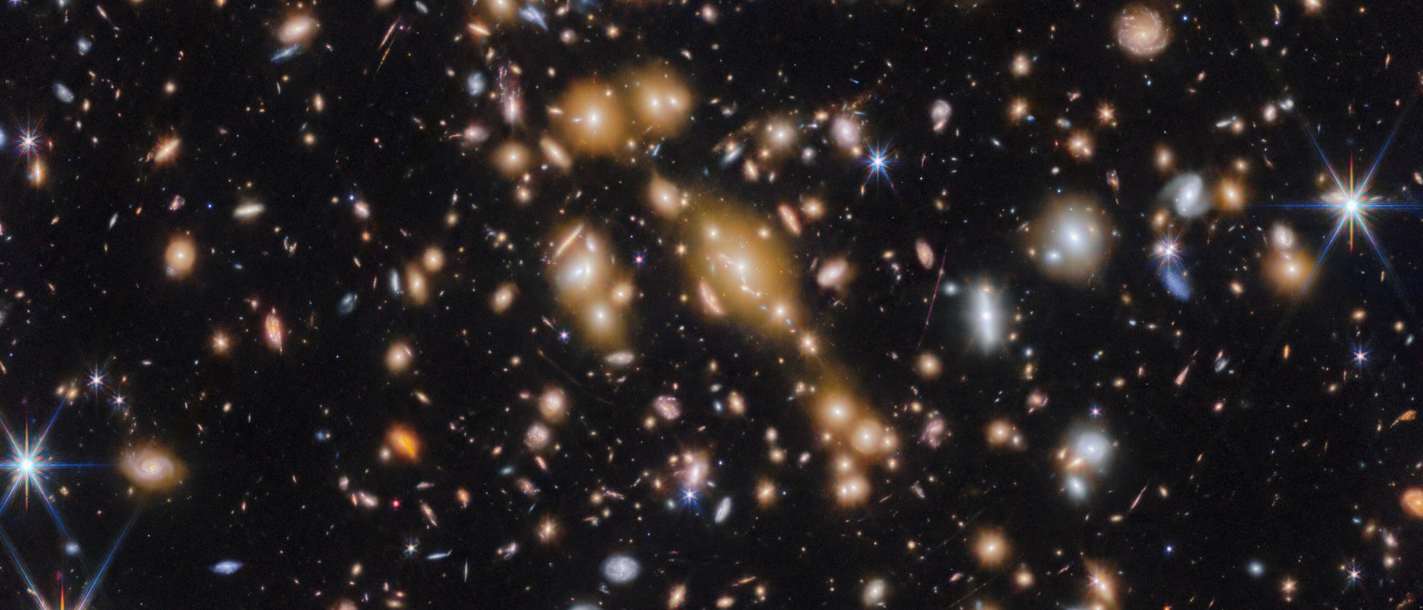 Ein Bild des Weltraums, das eine Vielzahl von Galaxien in unterschiedlichen Formen und Farben zeigt, die über das gesamte Bild verteilt sind. Einige Galaxien erscheinen als helle, leuchtende Punkte, während andere spiralförmige Strukturen aufweisen. Im Hintergrund ist ein dunkler, sternenübersäter Himmel zu sehen. Die Aufnahme vermittelt die Weite und Vielfalt des Universums. Ein Bild des Weltraums, das eine Vielzahl von Galaxien in unterschiedlichen Formen und Farben zeigt, die über das gesamte Bild verteilt sind. Einige Galaxien erscheinen als helle, leuchtende Punkte, während andere spiralförmige Strukturen aufweisen. Im Hintergrund ist ein dunkler, sternenübersäter Himmel zu sehen. Die Aufnahme vermittelt die Weite und Vielfalt des Universums.