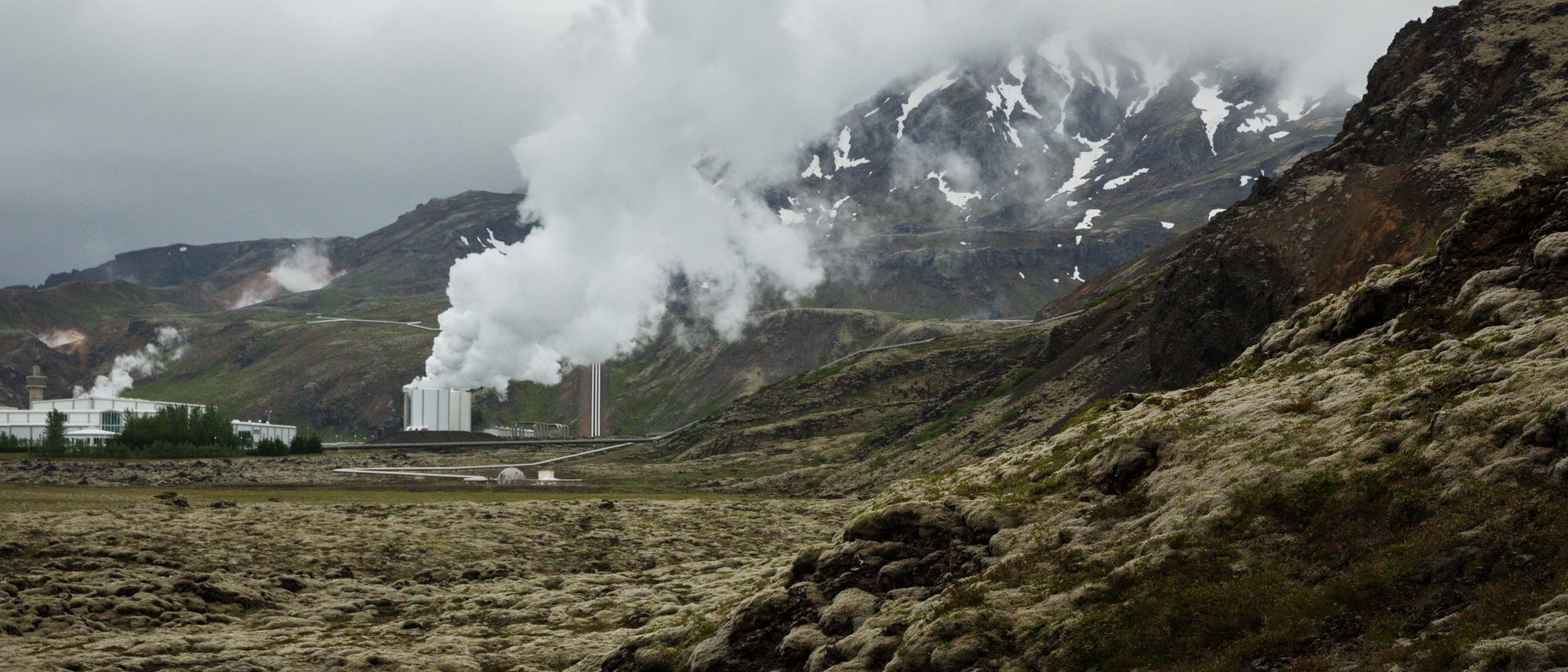 Isländische Landschaft mit dampfendem Erdwärmekraftwerk im Zentrum