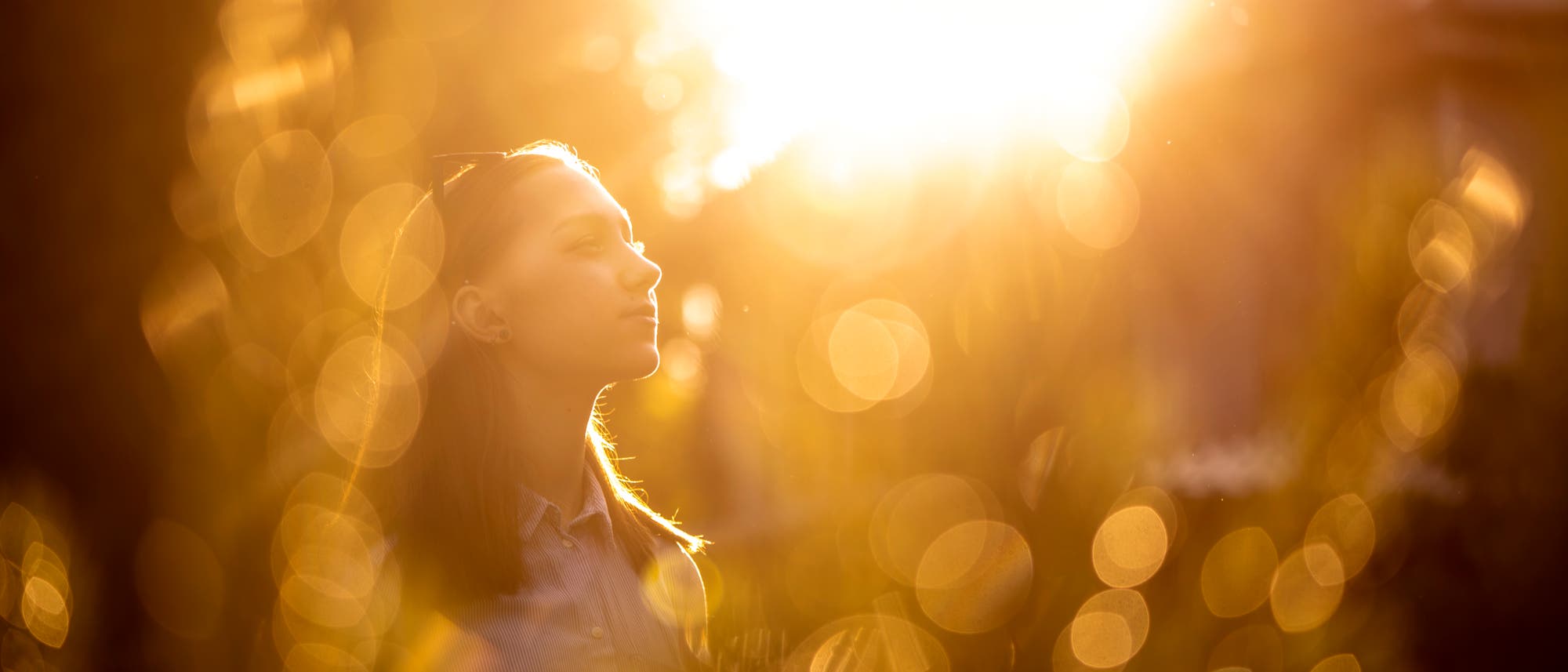 Gesicht einer jungen Frau im Gegenlicht