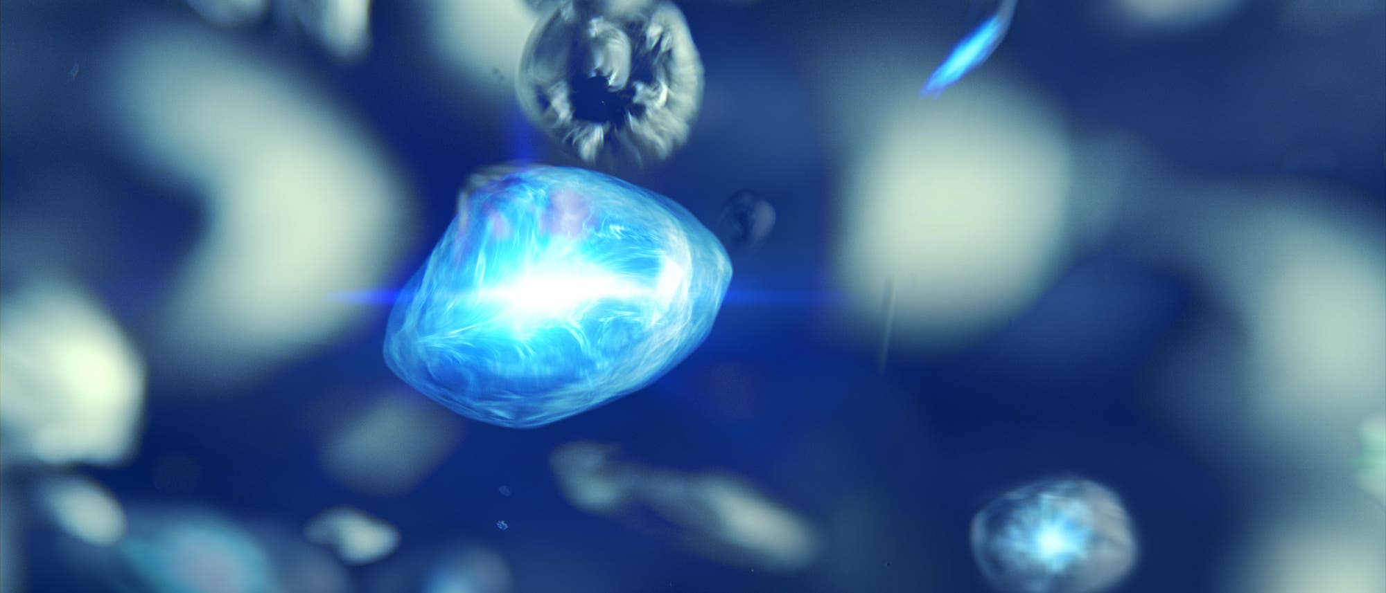 Eine 3-D-Darstellung von einem schwebenden, leuchtenden blauen Kristall im Zentrum des Bildes vor einem unscharfen, blauen Hintergrund. Der Kristall scheint Energie auszustrahlen und ist von kleineren, unscharfen Partikeln umgeben. Die Szene vermittelt ein Gef&uuml;hl von Bewegung und Tiefe.