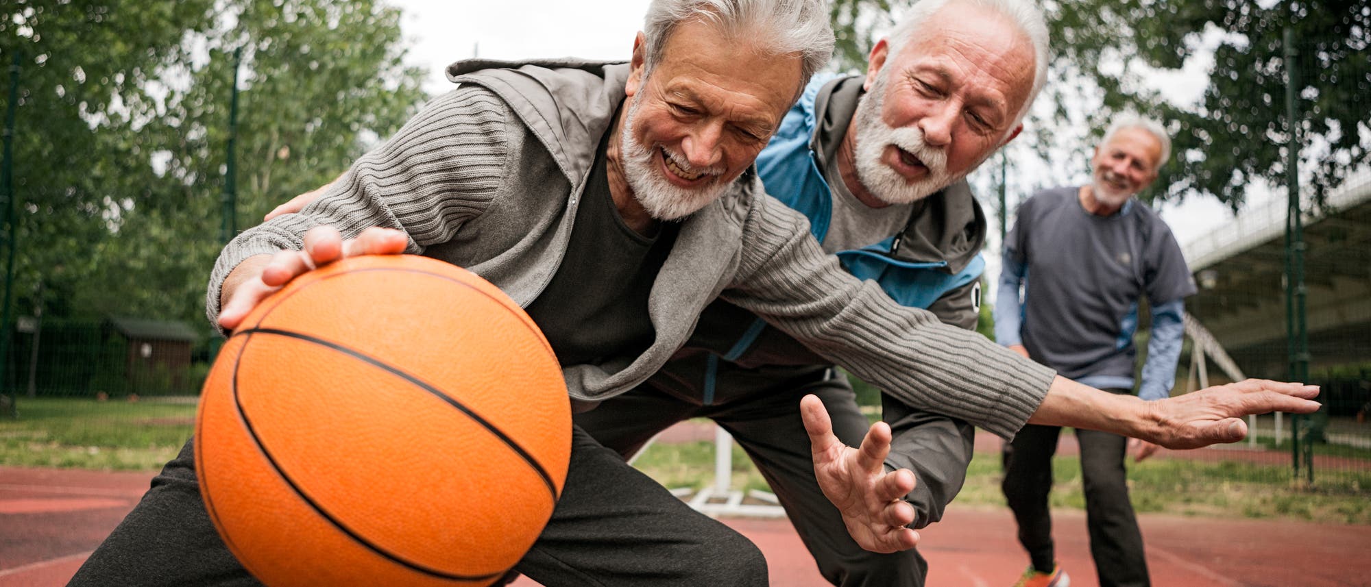 Senioren spielen draußen Basketball