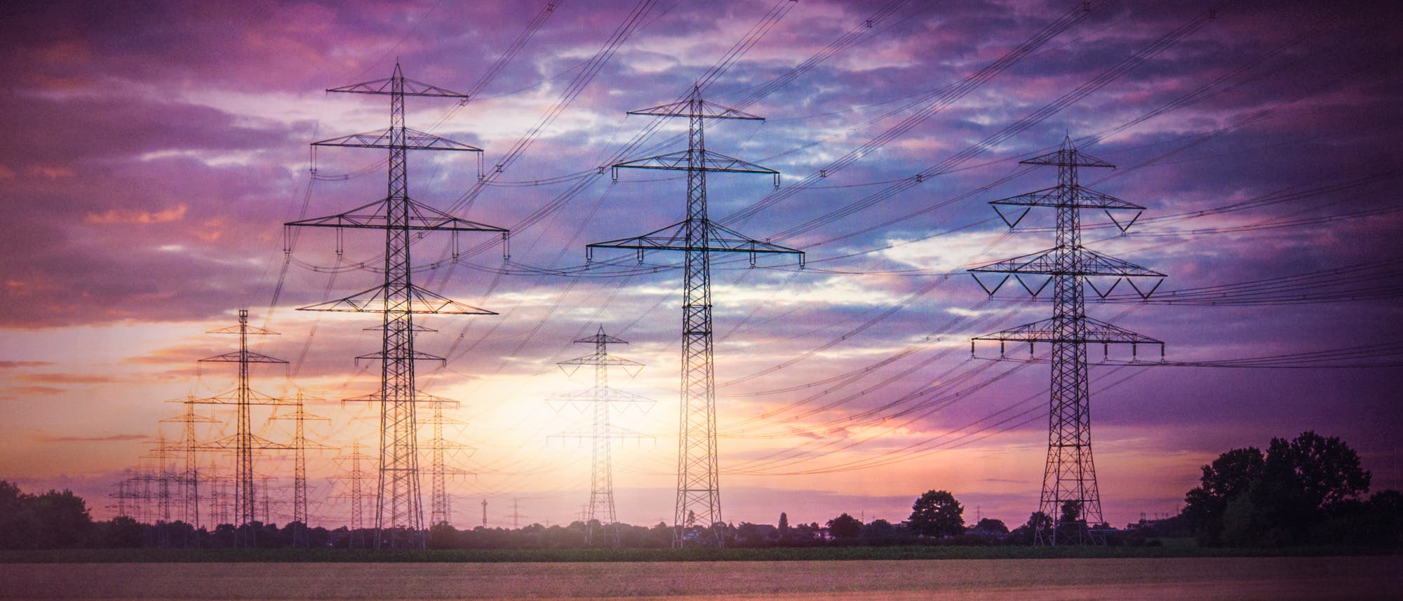 Stromtrasse vor violett gefärbtem Himmel