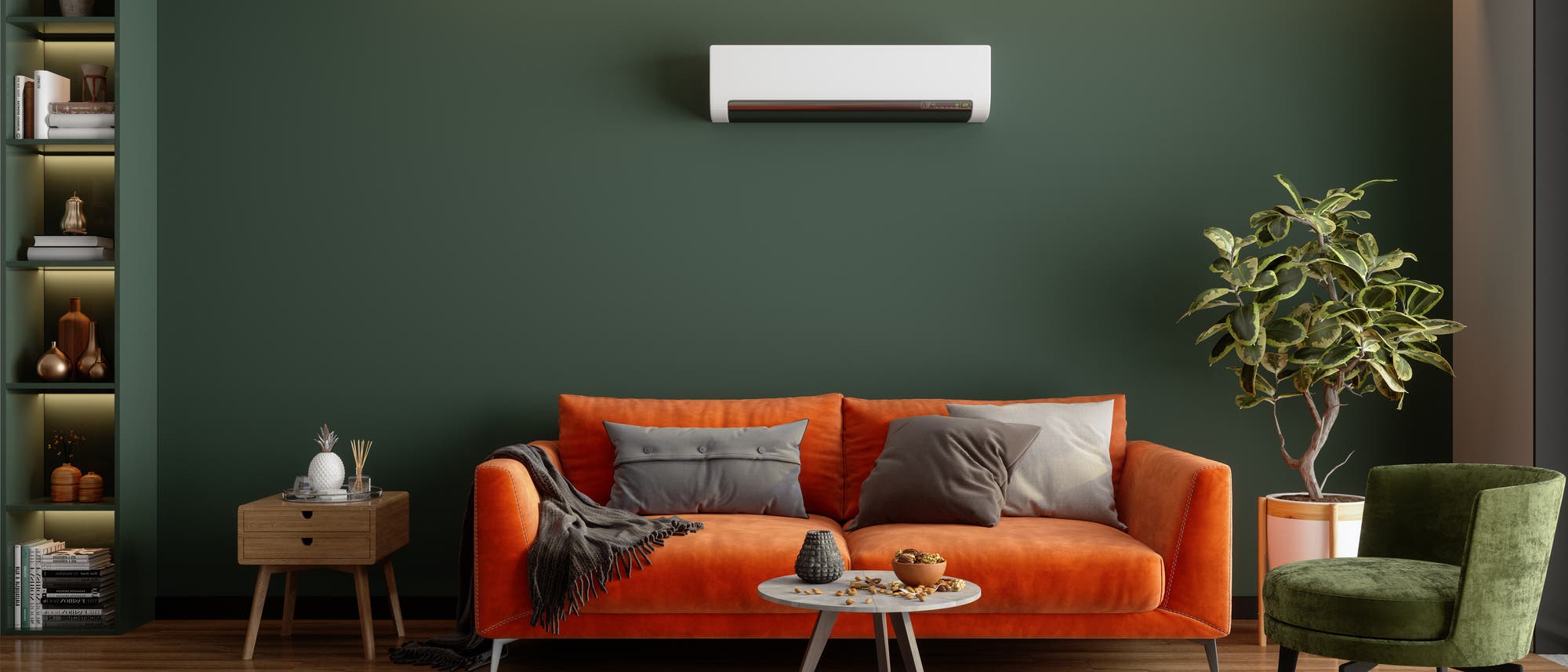 Ein stilvoll eingerichtetes Wohnzimmer mit einem orangefarbenen Sofa, dekoriert mit grauen Kissen und einer Decke. Vor dem Sofa steht ein runder Couchtisch mit Dekorationsgegenständen. Eine grüne Wand im Hintergrund trägt eine Klimaanlage. Links befindet sich ein Regal mit dekorativen Objekten, rechts ein grüner Sessel und eine Pflanze in einem Topf. Der Boden ist aus Holz, und ein gemusterter Teppich liegt vor dem Sofa. Ein stilvoll eingerichtetes Wohnzimmer mit einem orangefarbenen Sofa, dekoriert mit grauen Kissen und einer Decke. Vor dem Sofa steht ein runder Couchtisch mit Dekorationsgegenständen. Eine grüne Wand im Hintergrund trägt eine Klimaanlage. Links befindet sich ein Regal mit dekorativen Objekten, rechts ein grüner Sessel und eine Pflanze in einem Topf. Der Boden ist aus Holz, und ein gemusterter Teppich liegt vor dem Sofa.